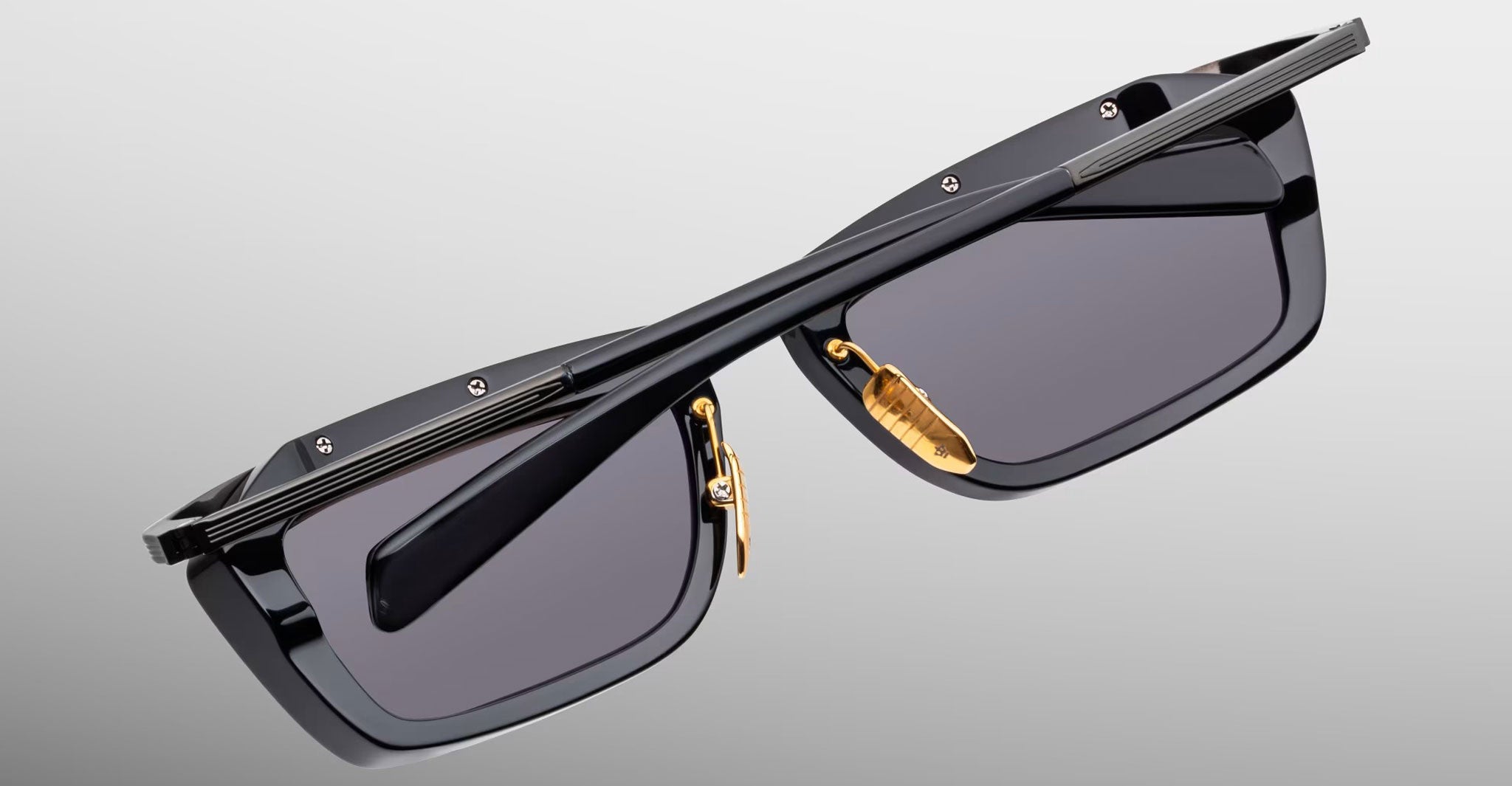 Jacques Marie Mage Gaspard black rectangular sunglasses with gold nose pads, front view.