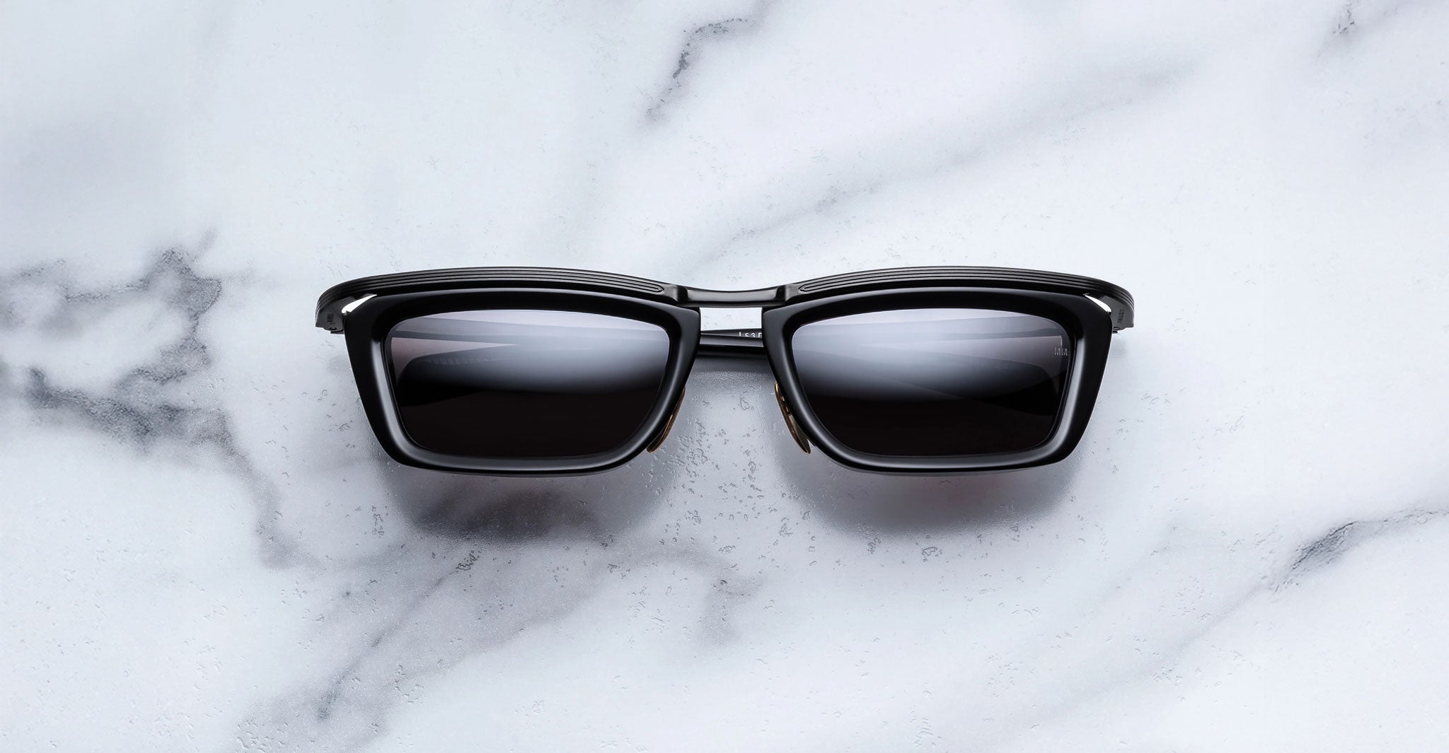 Jacques Marie Mage Gaspard black rectangular sunglasses with dark UV lenses, front view.