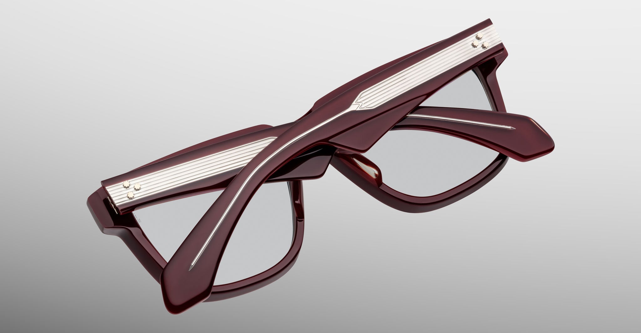 Jacques Marie Mage Hyannis in Bordeaux maroon eyeglasses, folded, with silver temple accents, shown from a back view.