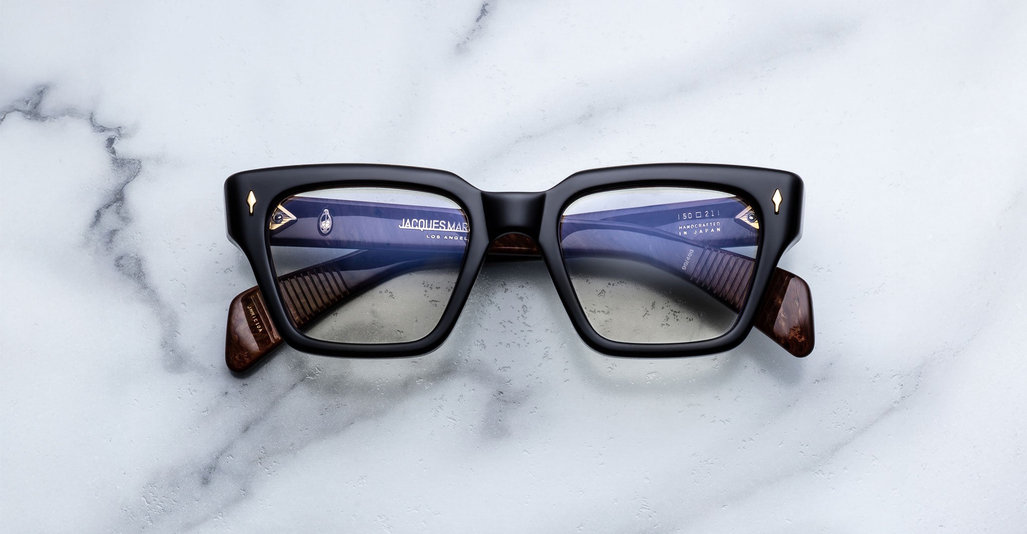 Jacques Marie Mage Ichikawa black rectangular eyeglasses with brown accents and tinted lenses, front view.