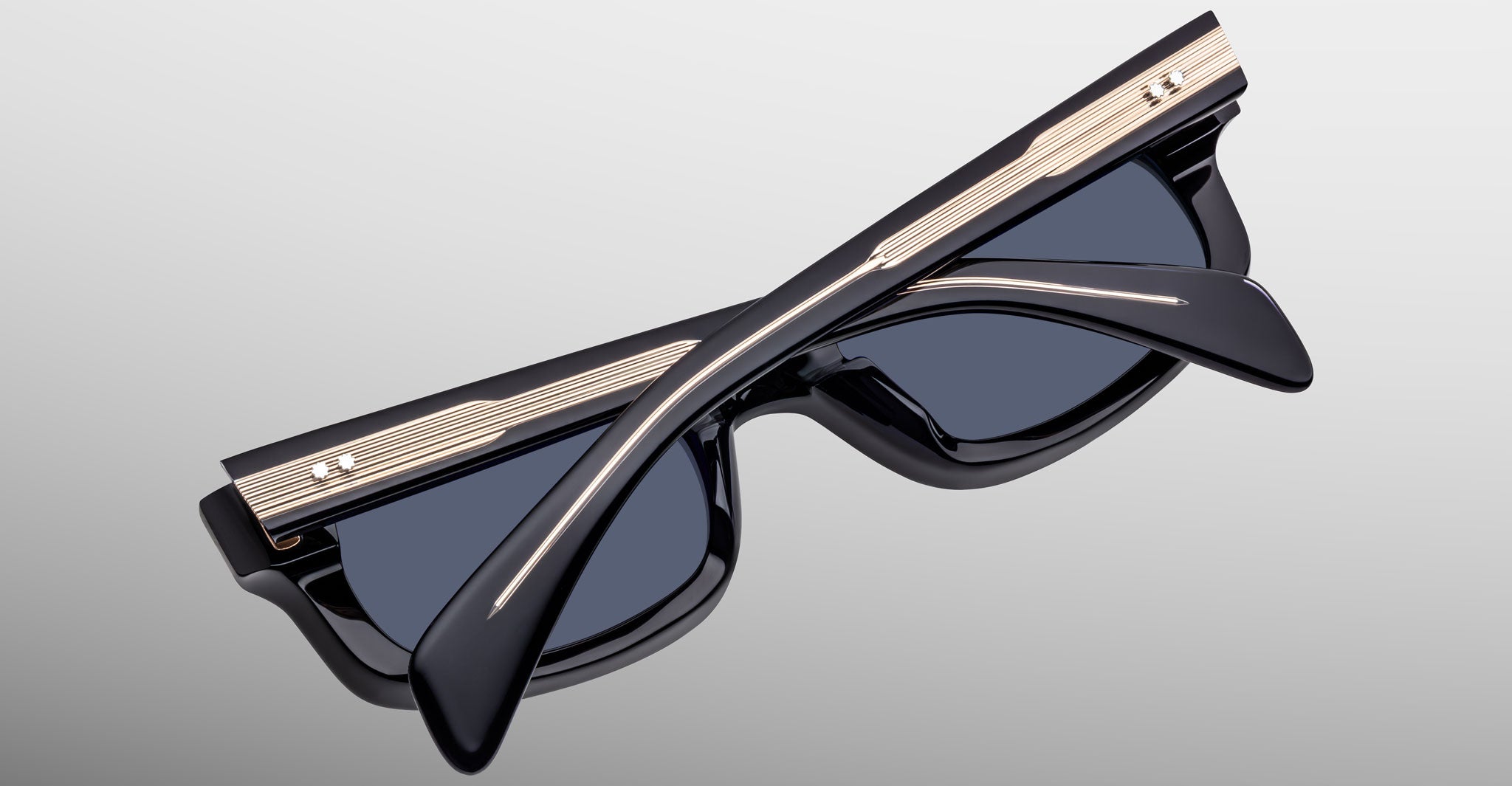 Jacques Marie Mage Initials in Lacquer sunglasses, dark blue frame with gold accents, folded, product shown from a back angle.