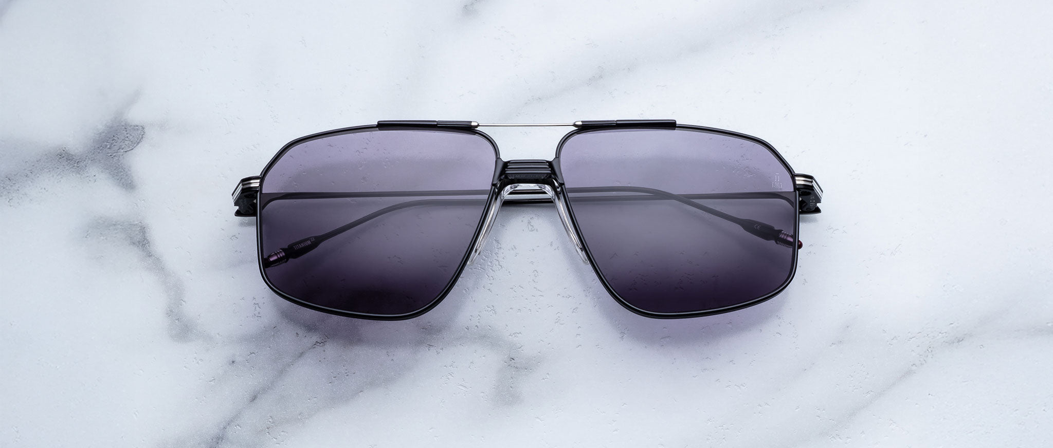 Jacques Marie Mage Jagger oversized aviator sunglasses with dark tinted lenses by Jacques Marie Mage, displayed on a white marble surface.