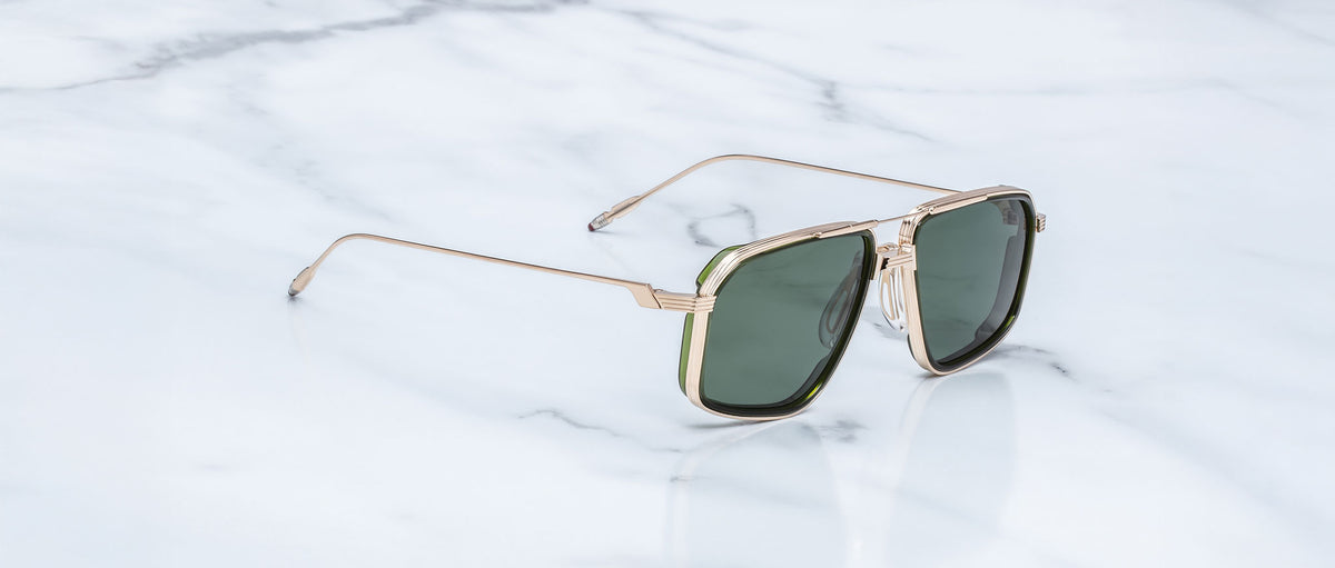 Jacques Marie Mage Jagger sunglasses, gold frame and green lenses, viewed from above.