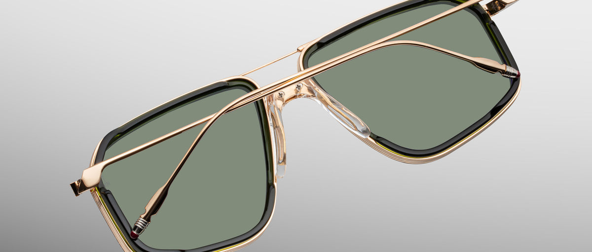 Jacques Marie Mage Jagger sunglasses with gold frames and green lenses, shown from the front.