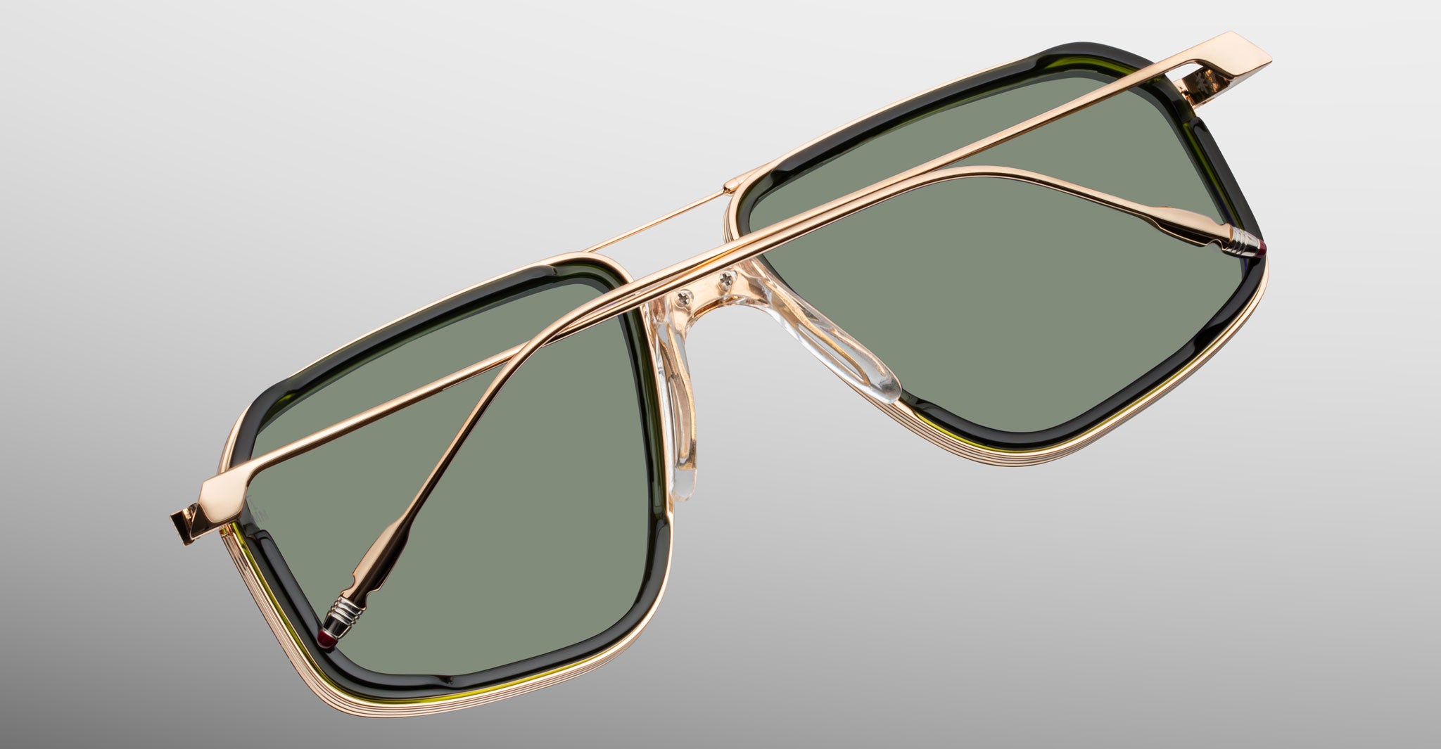 Jacques Marie Mage Jagger sunglasses with gold frames and green lenses, shown from the front.
