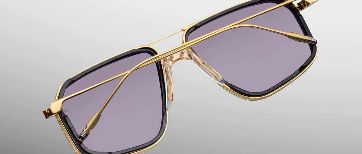 Jacques Marie Mage Jagger sunglasses with gold frames and rectangular purple lenses, shown from the front.