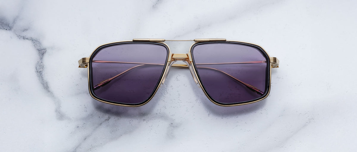Jacques Marie Mage Jagger aviator sunglasses with gold frames and dark lenses, top view.