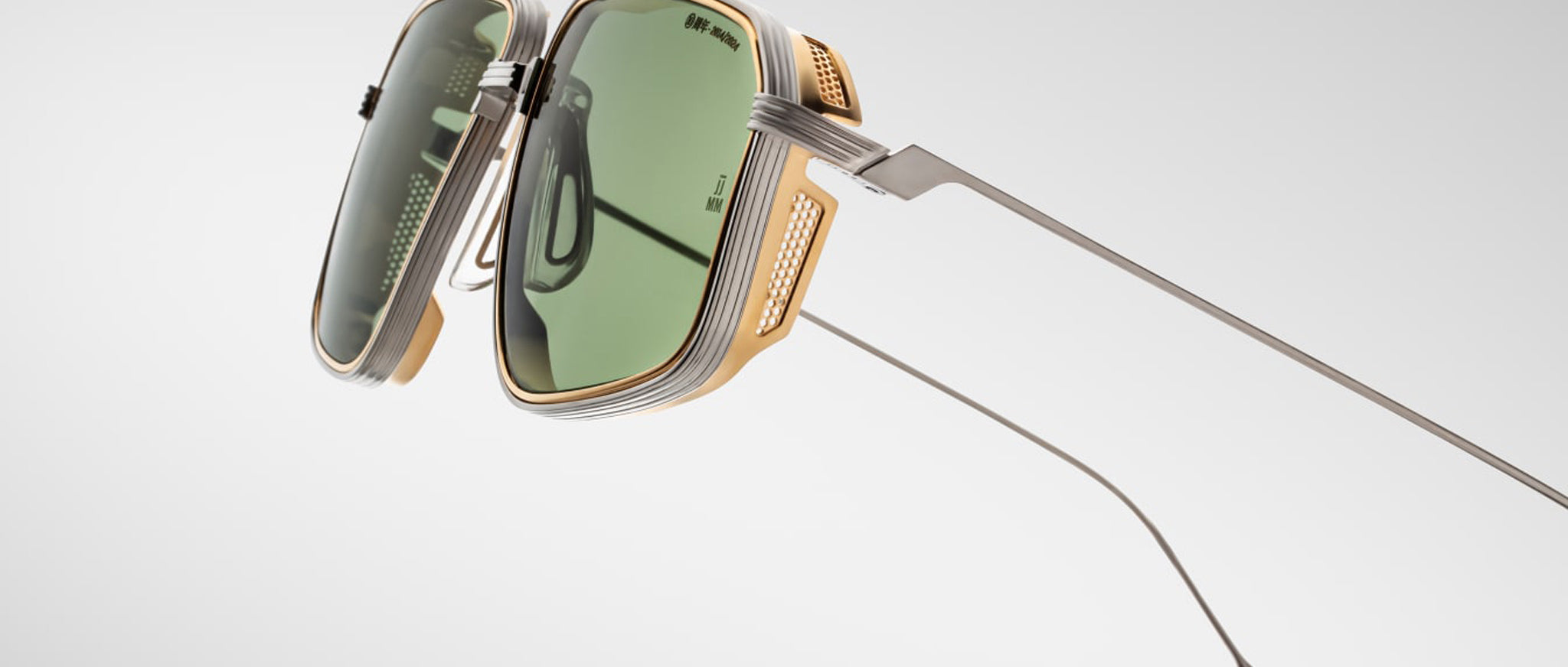 The Jacques Marie Mage Jagger sunglasses feature oversized aviator green lenses, metallic gold and silver beta titanium frames, and sleek long temples by Jacques Marie Mage, photographed against a plain background.