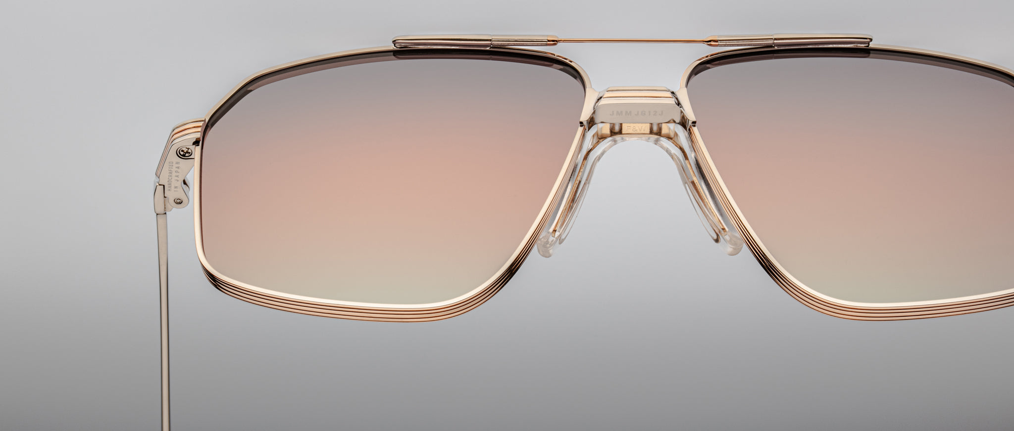 Close-up of Jacques Marie Mage Jagger aviator sunglasses featuring oversized gold frames and gradient brown-tinted lenses, set against a neutral background.