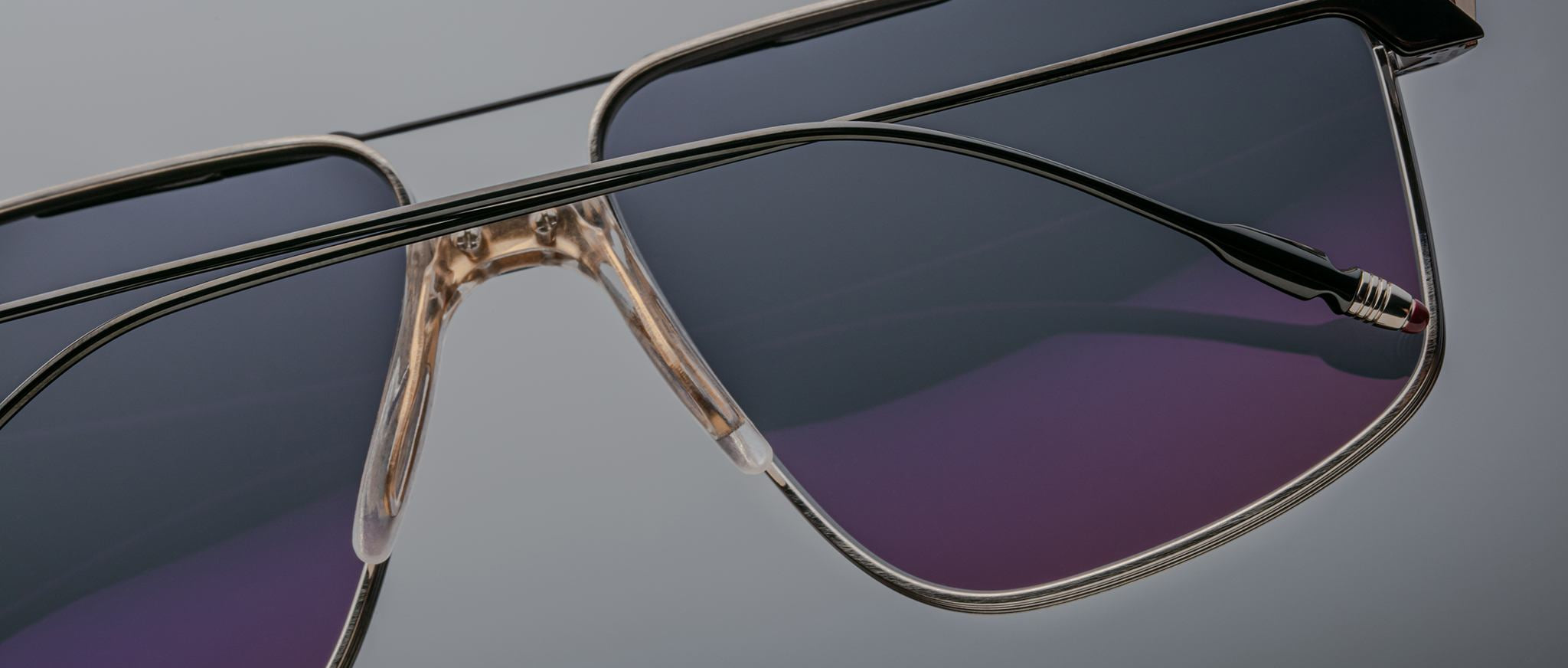 Close-up of Jacques Marie Mage Jagger oversized aviator sunglasses featuring thin beta titanium frames and dark tinted lenses, by Jacques Marie Mage, set against a plain background.
