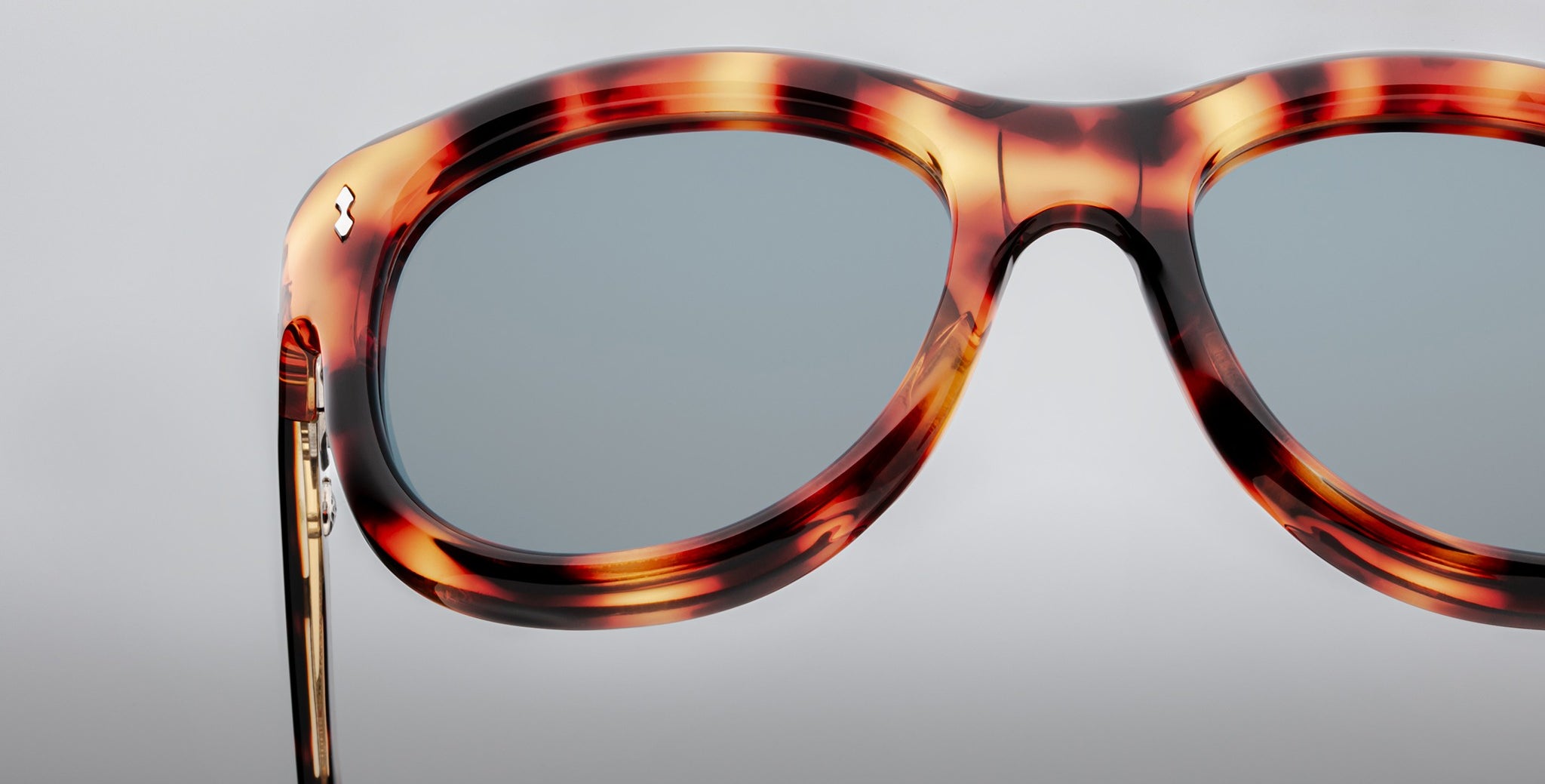 Close-up of Jacques Marie Mage Jennie sunglasses, tortoiseshell frames, blue-tinted UV lenses, viewed from the front.