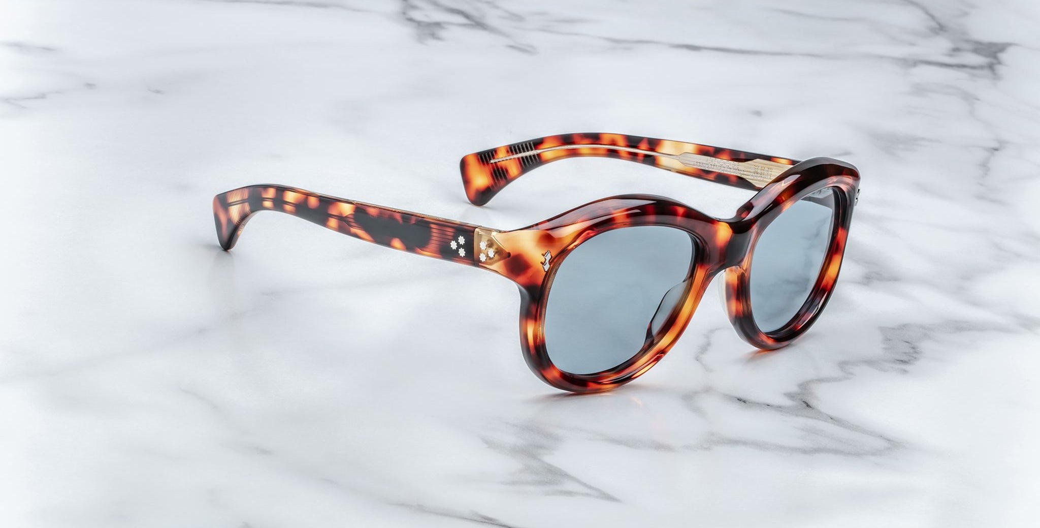 Jacques Marie Mage Jennie round tortoiseshell sunglasses with blue lenses, shown from above.