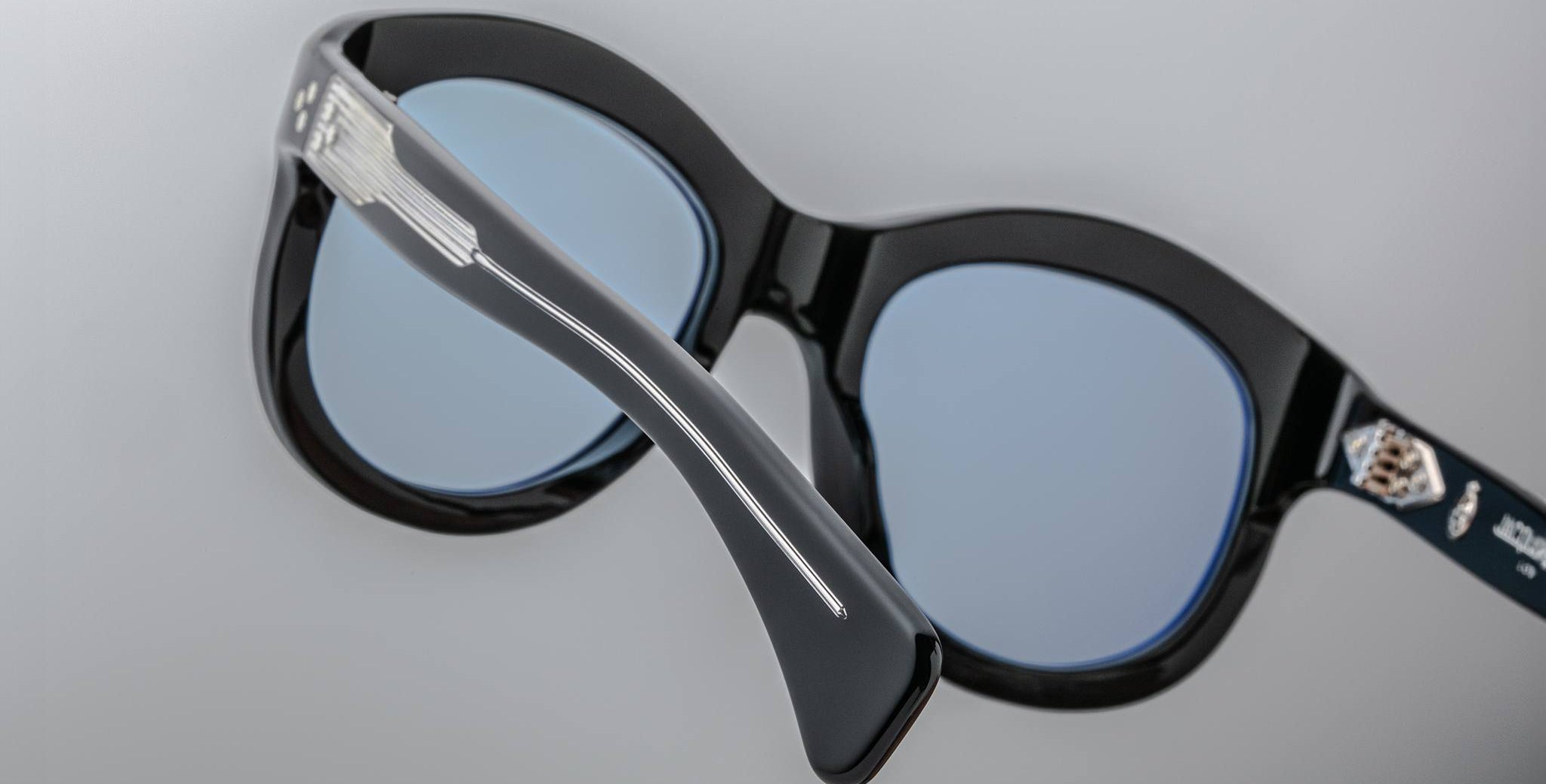 Close-up of the back of Jacques Marie Mage Jennie sunglasses showing blue-tinted lenses and a silver accent on the frame.