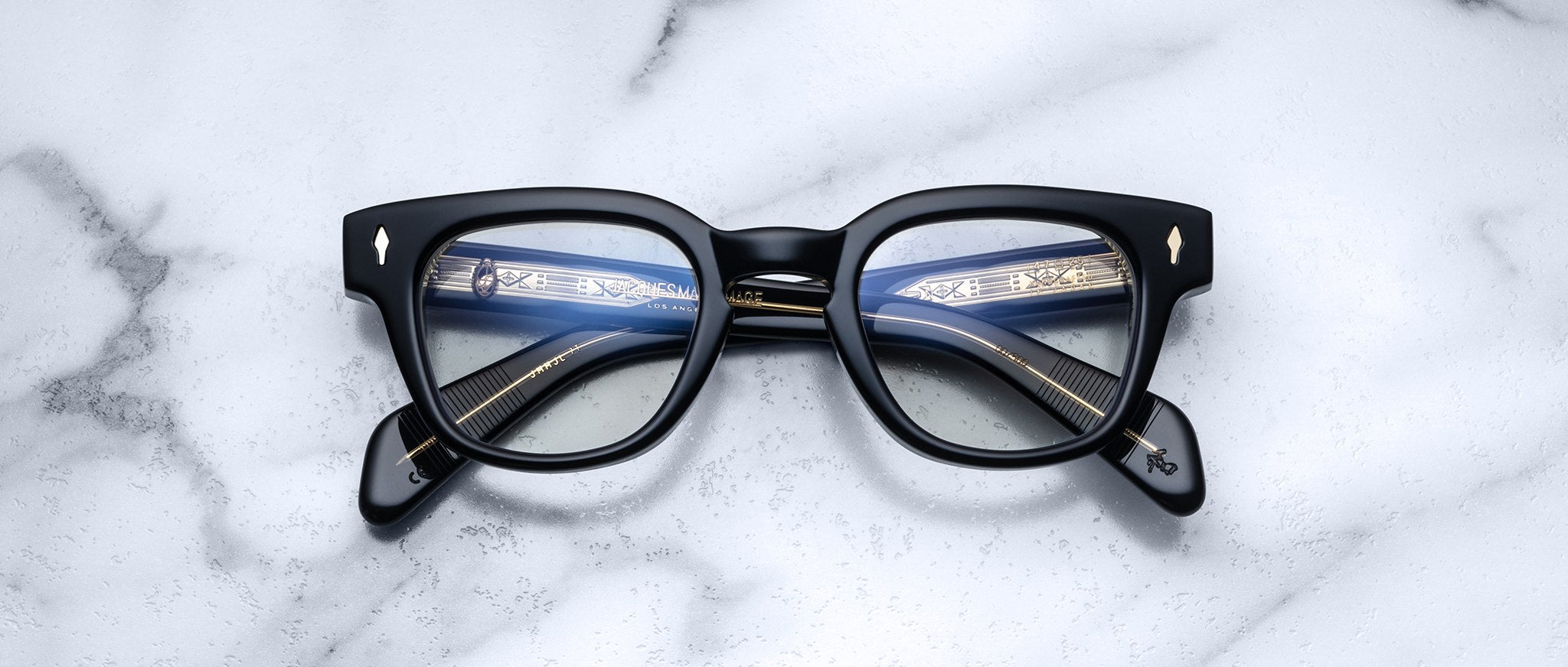 Jacques Marie Mage Julien in Beluga rectangular optical frame in deep black acetate with a smooth, polished finish, featuring a keyhole bridge, signature arrowhead front pins, and exposed metal core detailing within the temples, shown with clear lenses.