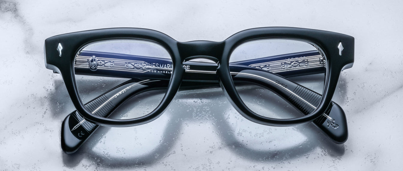 Jacques Marie Mage Julien in Titan black rectangular optical frame in acetate with cool-toned undertones, featuring a keyhole bridge, signature arrowhead front pins, and exposed metal core detailing within the temples, shown with clear lenses.