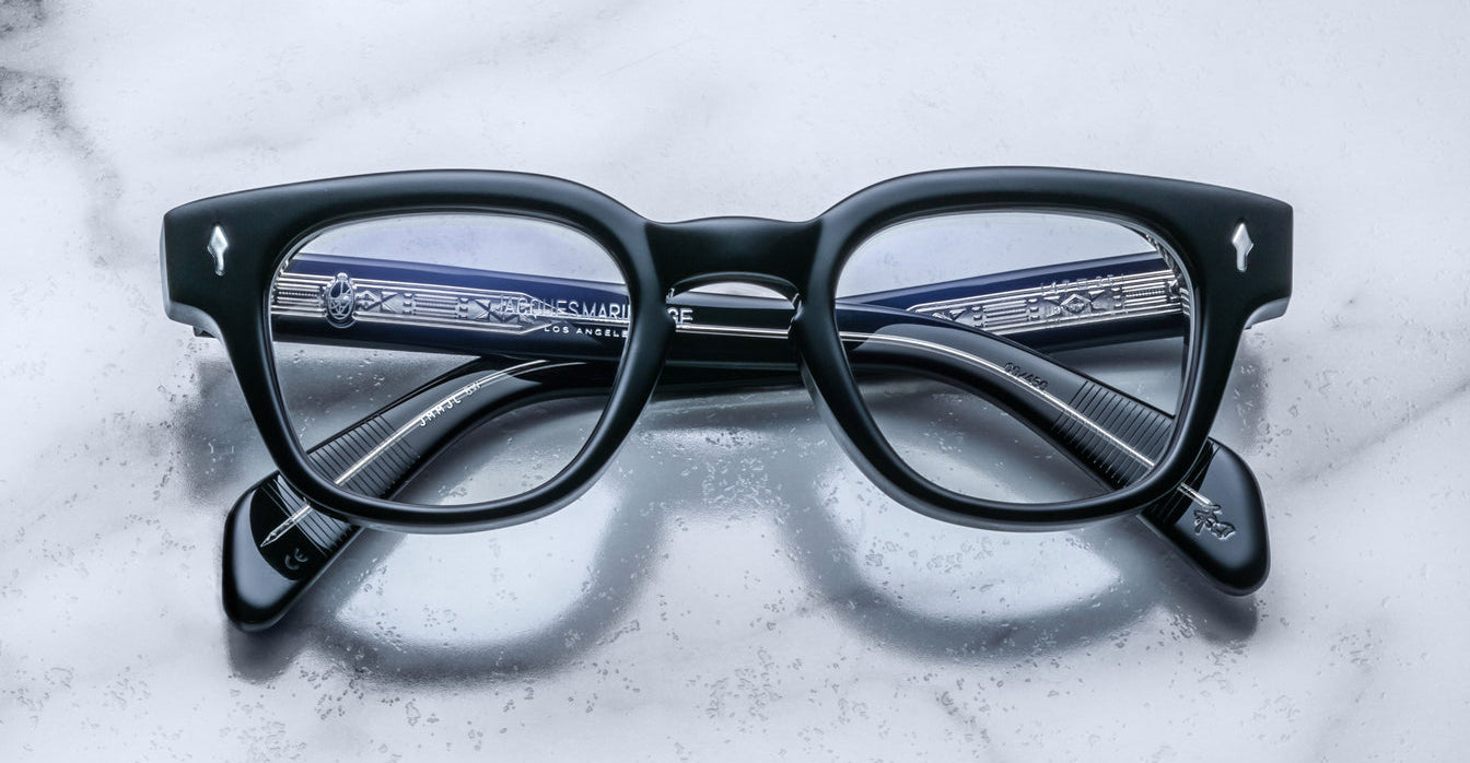 Jacques Marie Mage Julien in Titan black rectangular optical frame in acetate with cool-toned undertones, featuring a keyhole bridge, signature arrowhead front pins, and exposed metal core detailing within the temples, shown with clear lenses.