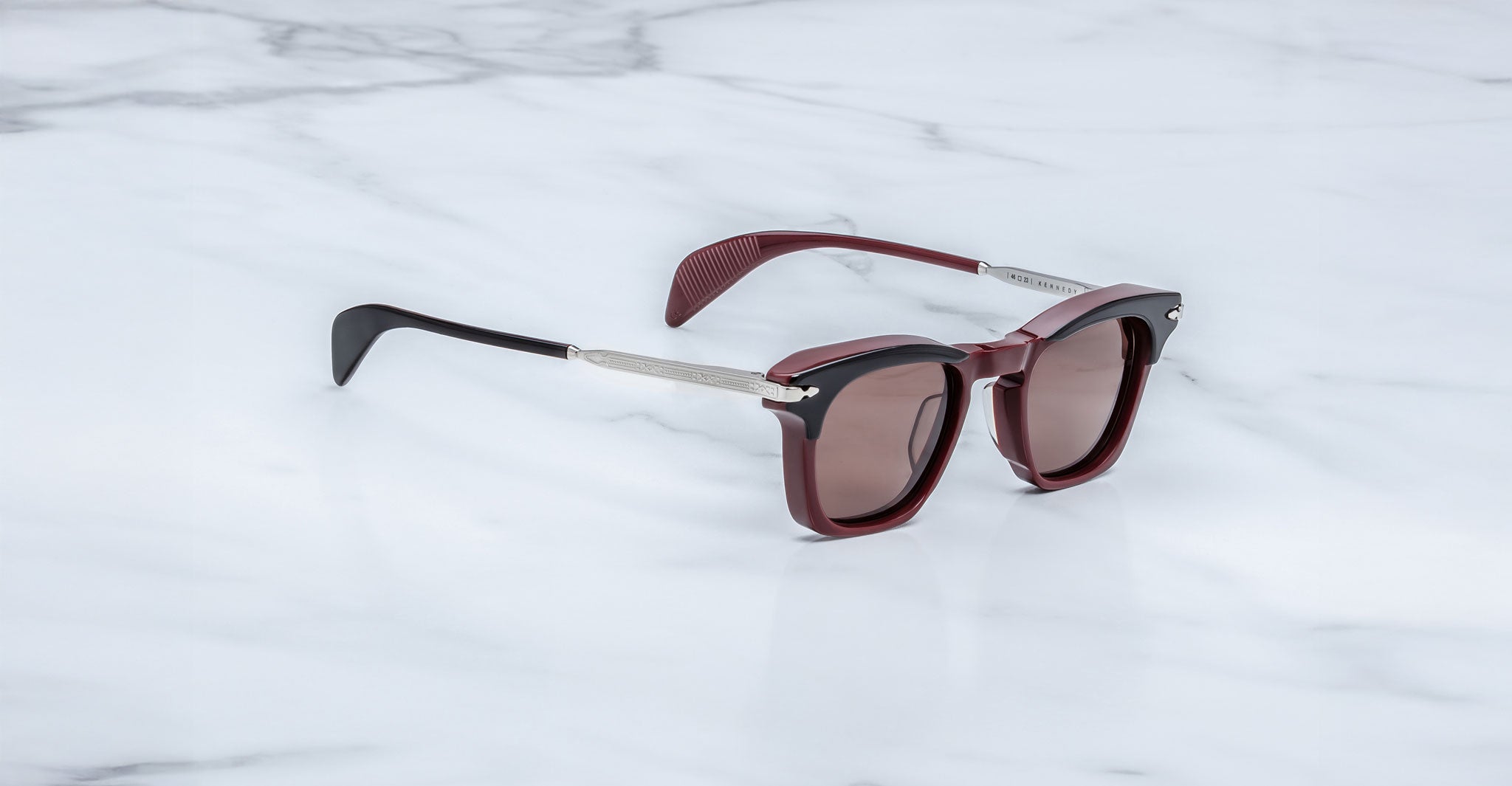 Jacques Marie Mage Kennedy sunglasses in maroon and black with rectangular lenses, top view.