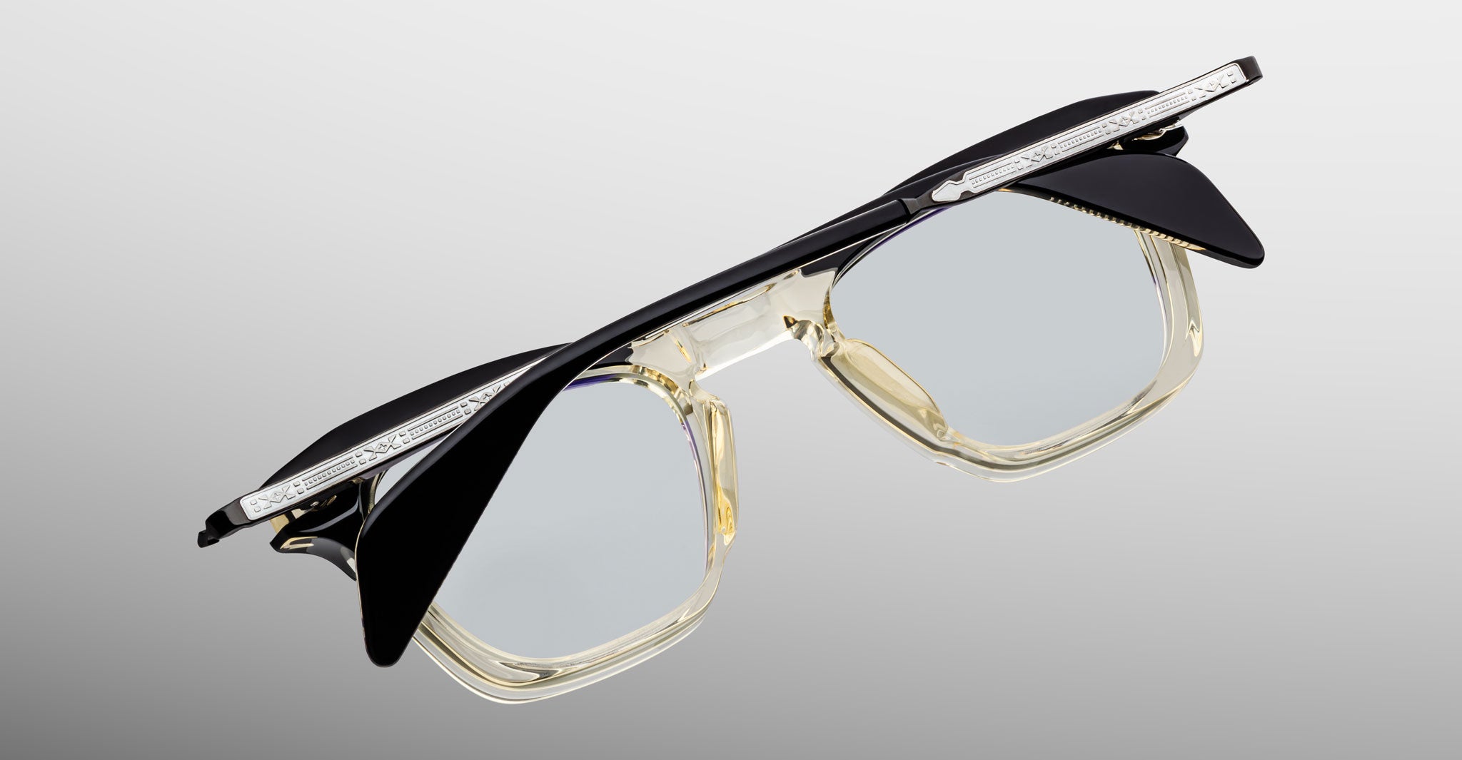 Jacques Marie Mage Kennedy eyeglasses, clear frames with black upper rims and silver temples, shown from a front-facing angle.