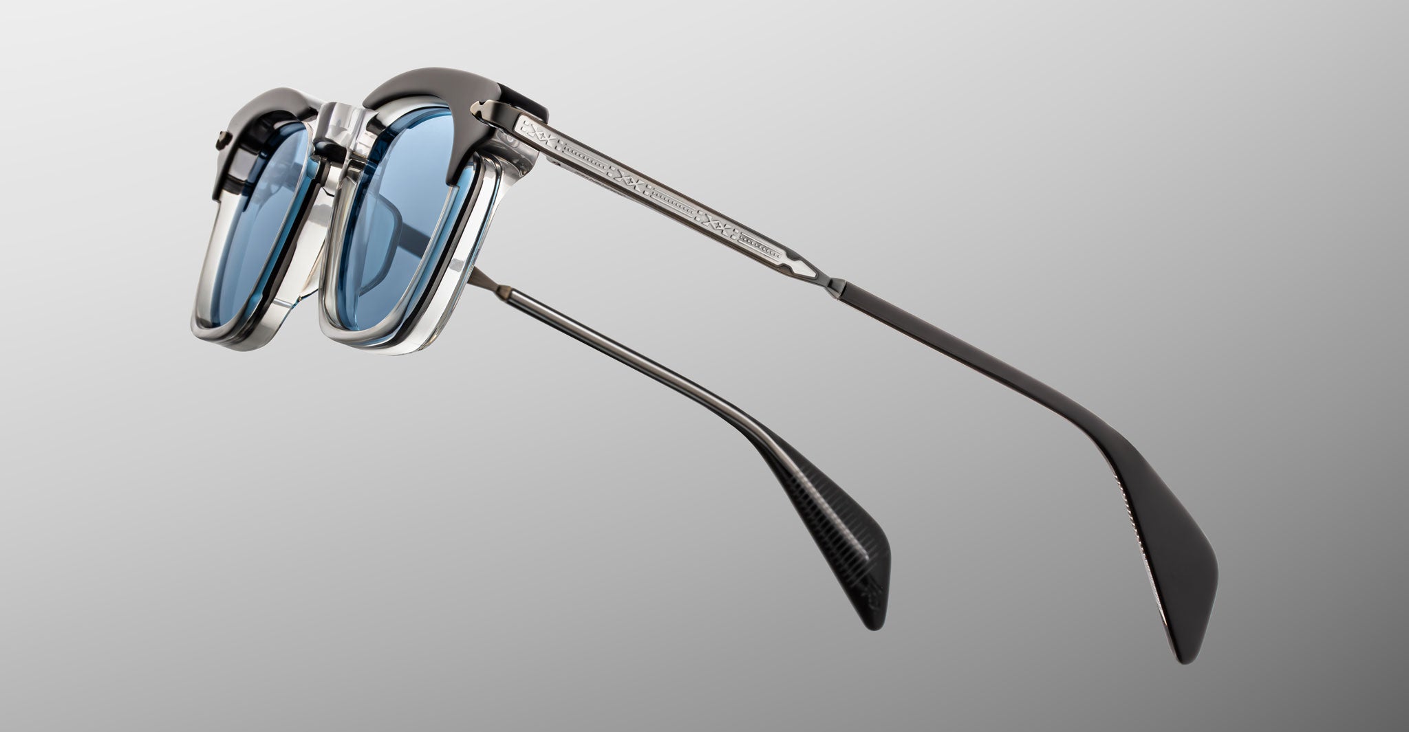 Jacques Marie Mage Kennedy eyeglasses with black and silver frame, blue lenses, and textured metal arms, front view.