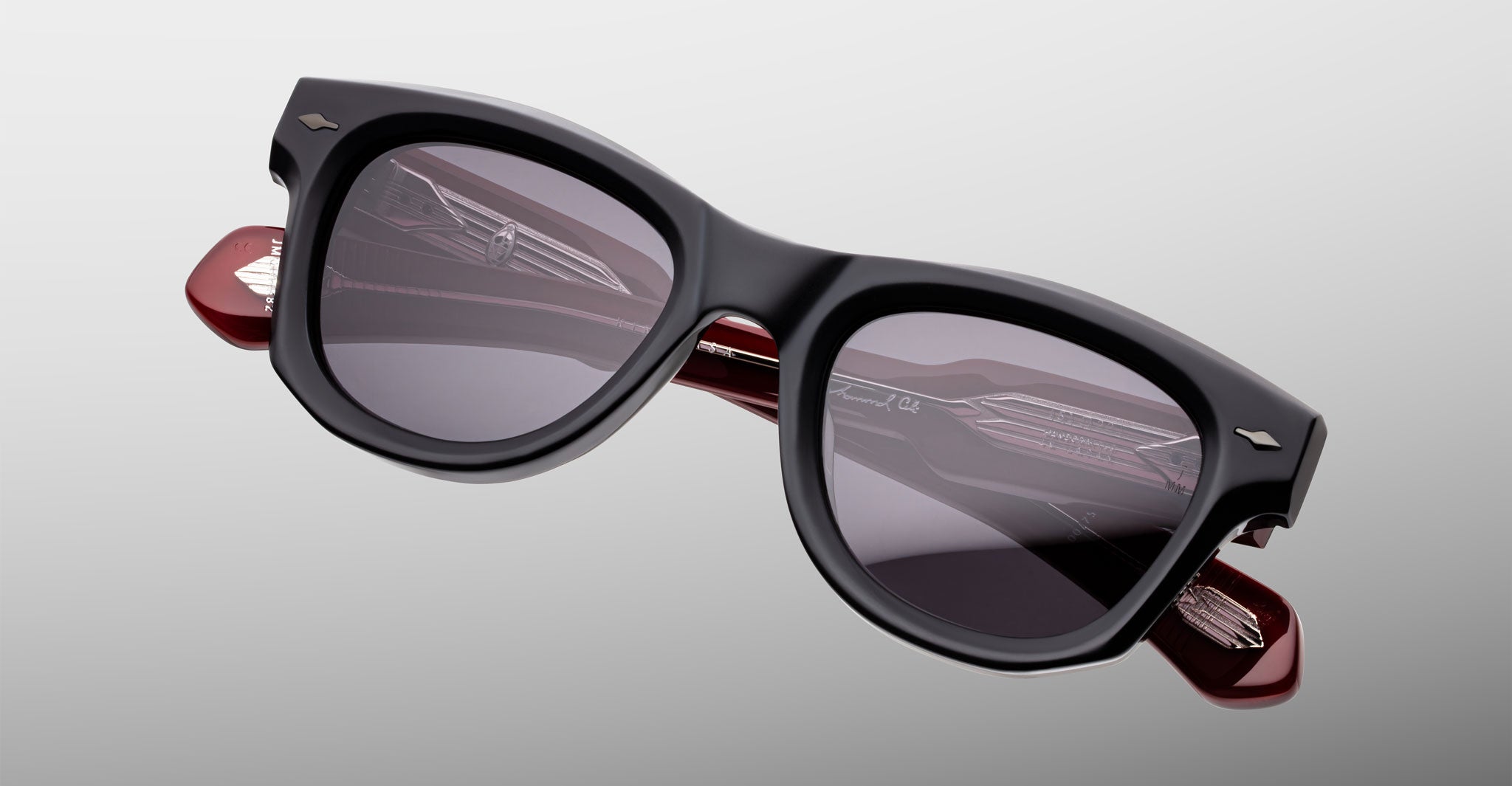 Jacques Marie Mage Kinshasa sunglasses, black polarized frames, dark lenses, red arms, front view.