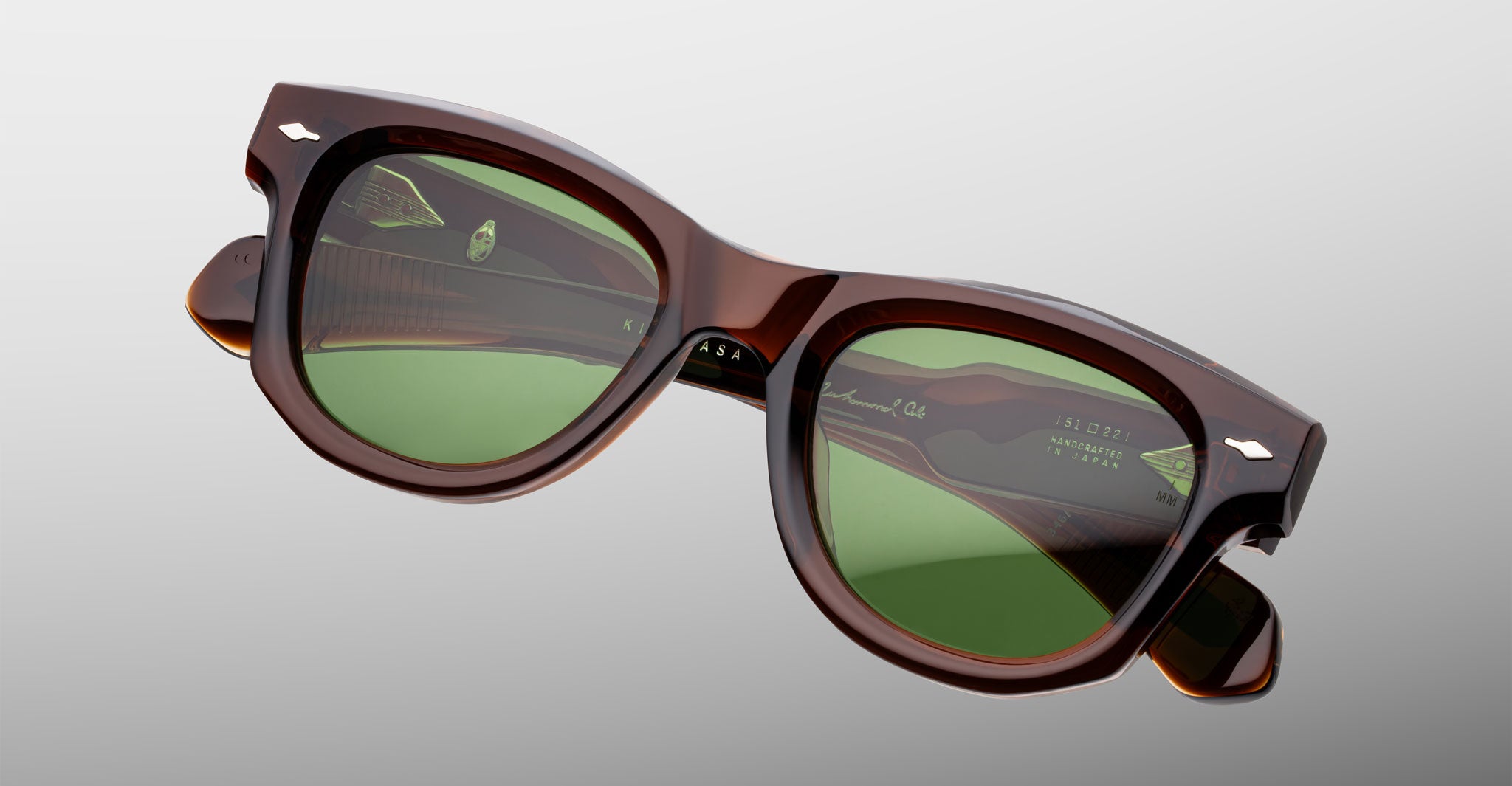 Jacques Marie Mage Kinshasa sunglasses with brown frame and green polarized lenses, front view.