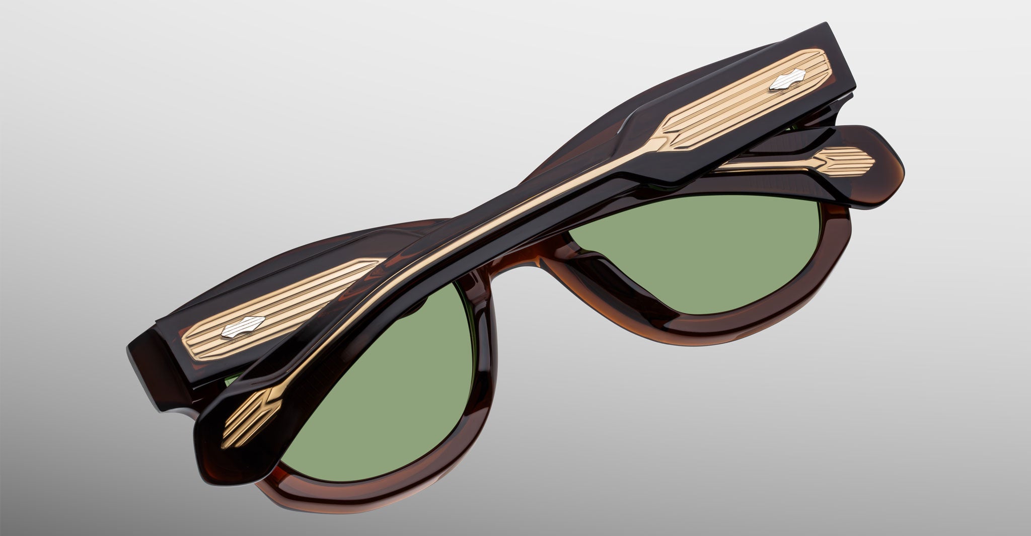 Jacques Marie Mage Kinshasa sunglasses, folded, shown from above with green lenses, brown frames, and gold arm accents.