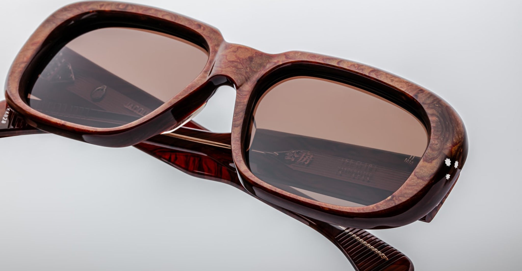 Close-up of Jacques Marie Mage Kobo sunglasses showing marbled rectangular frame and tinted lenses, front-facing angle.
