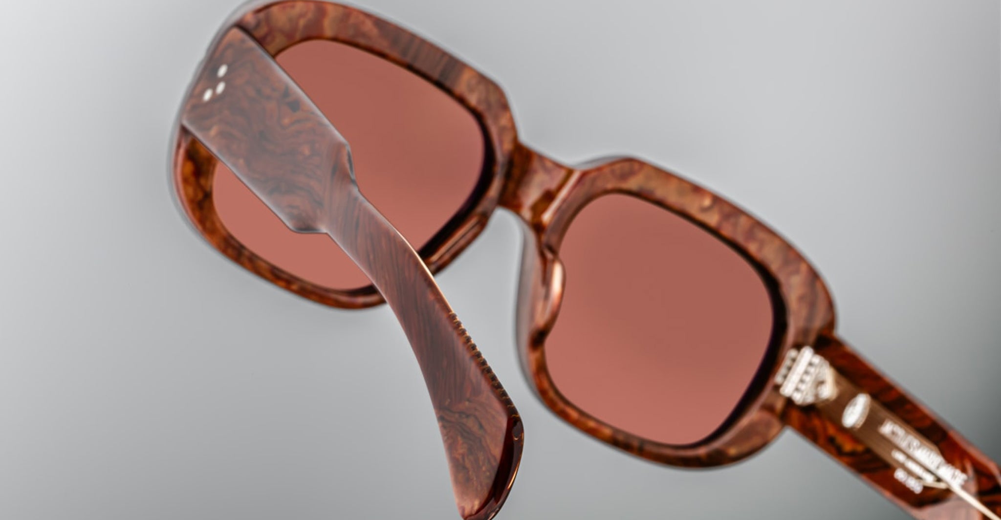 Close-up of Jacques Marie Mage Kobo sunglasses with rose-tinted UV protection lenses, front view.