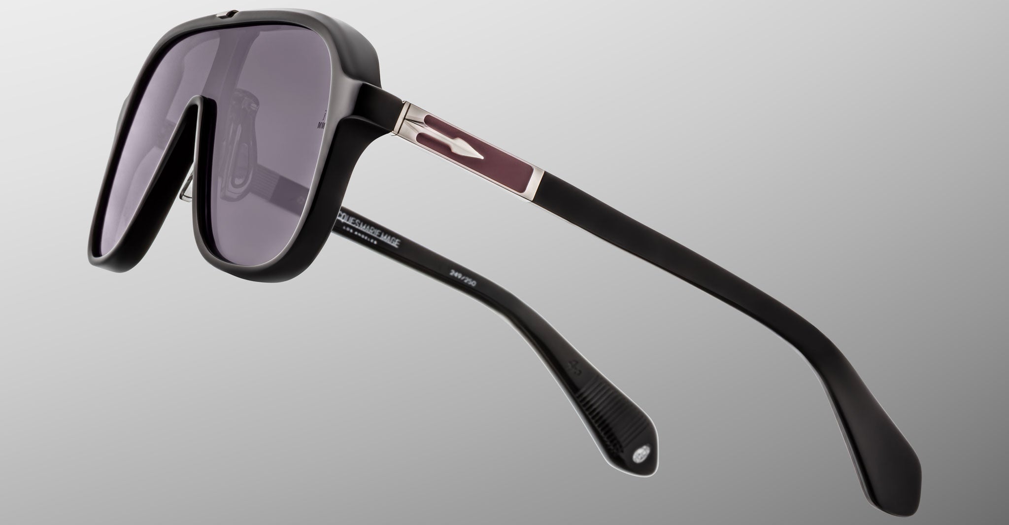 A close-up of Jacques Marie Mage Kurokawa black designer sunglasses featuring large tinted lenses and thick arms, photographed against a light grey background.