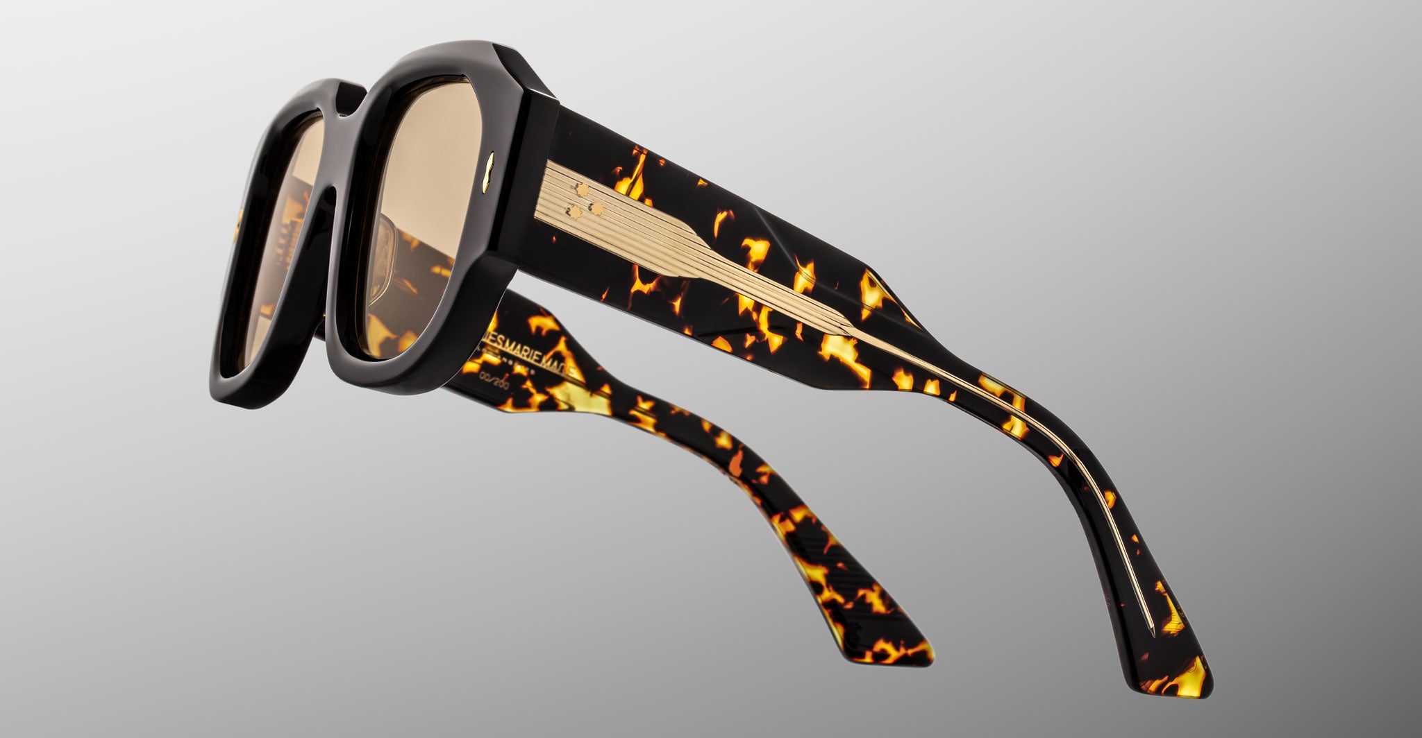 Close-up of Jacques Marie Mage Lacy sunglasses, retro tortoiseshell thick frames, gold temples, front view.