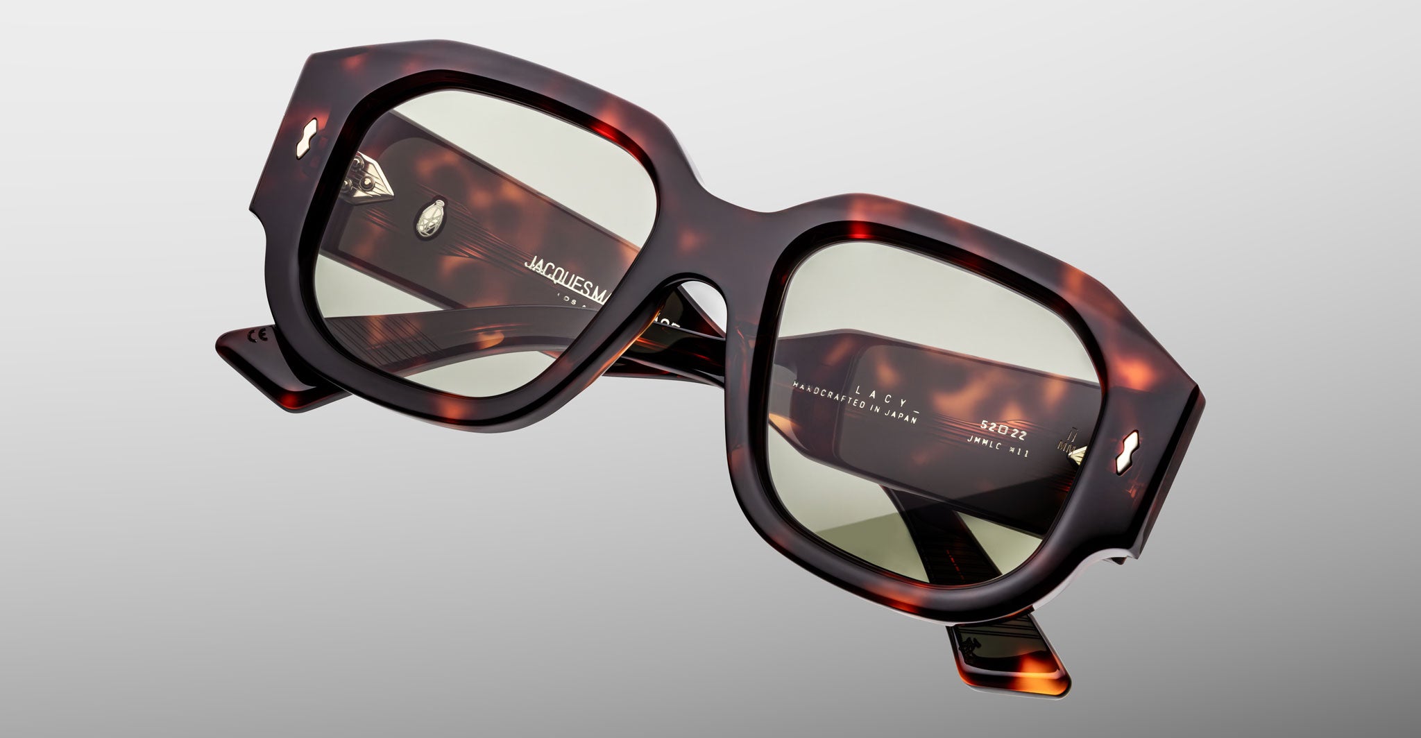 Close-up of Jacques Marie Mage Lacy square sunglasses with green lenses, viewed from the front.