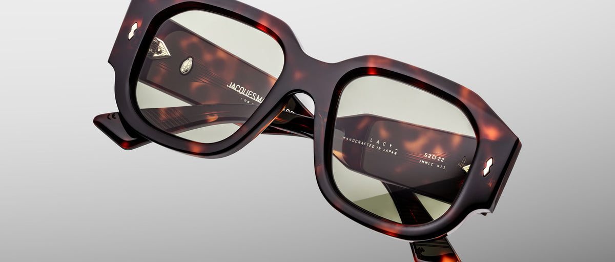 Close-up of Jacques Marie Mage Lacy square sunglasses with green lenses, viewed from the front.