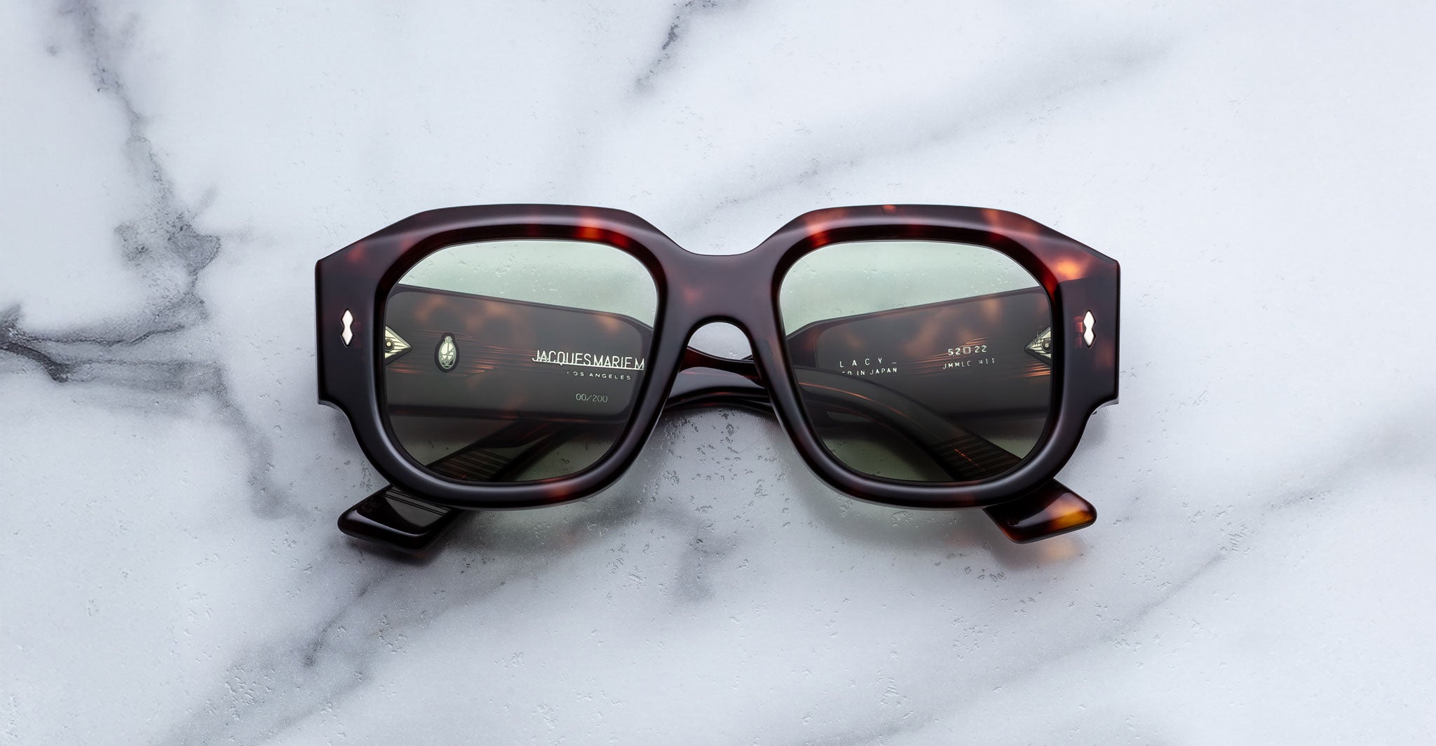 Jacques Marie Mage Lacy sunglasses with green polarized lenses, shown from above, display the brand and model clearly.