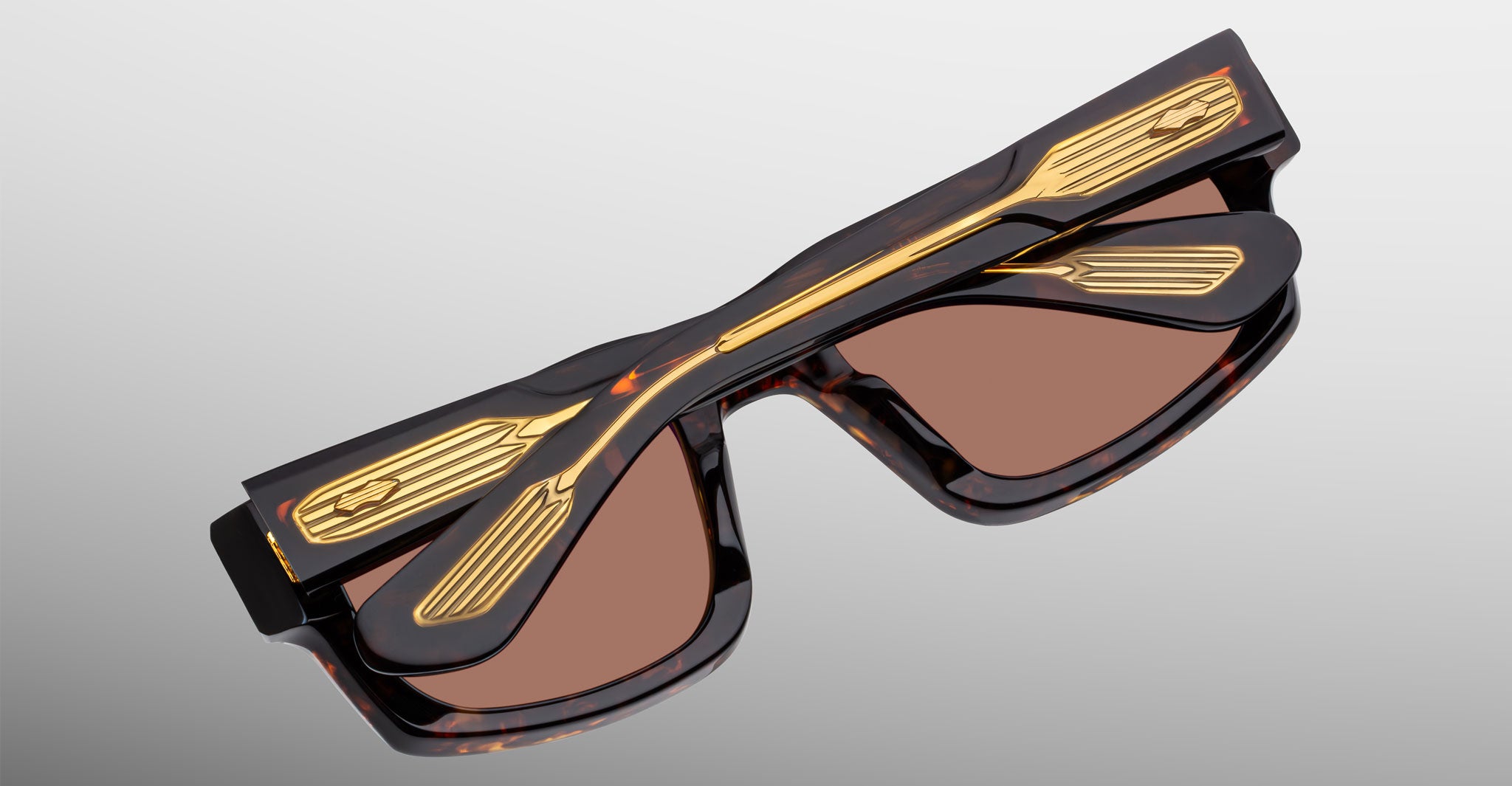 Jacques Marie Mage Louisville sunglasses, brown tortoiseshell with gold accents, shown folded from a top-down angle.