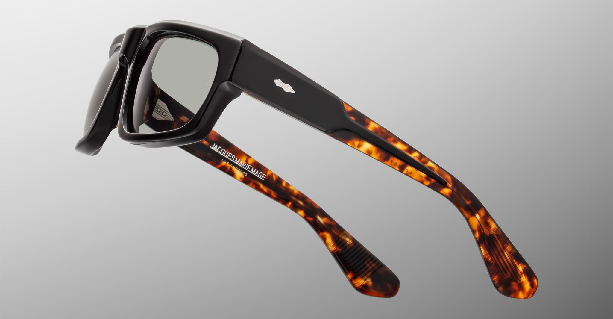Jacques Marie Mage Louisville sunglasses with UV protection, black front frames, and tortoiseshell-patterned side arms, front view.