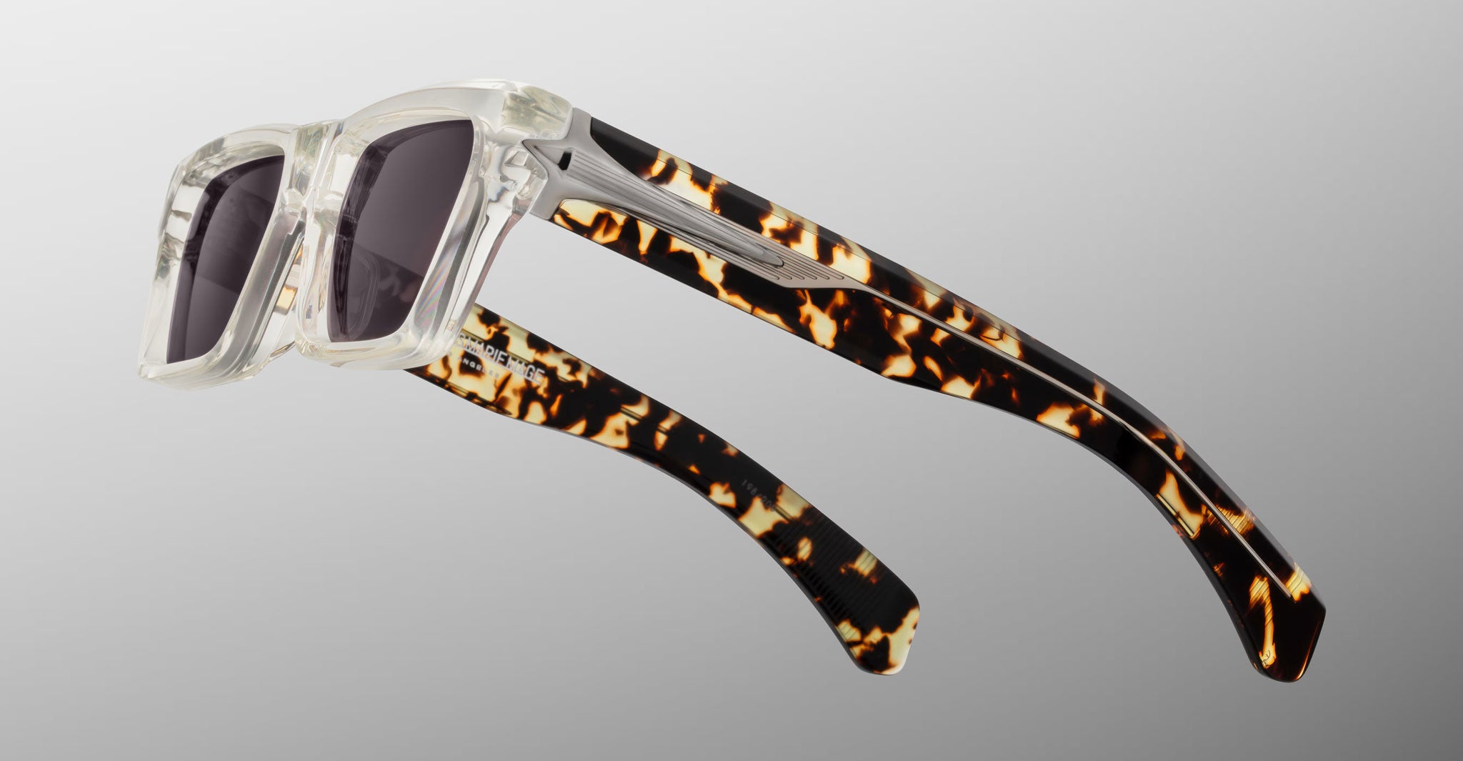 Jacques Marie Mage Melchior sunglasses with rectangular clear frames, dark lenses, and tortoiseshell temples, front view.