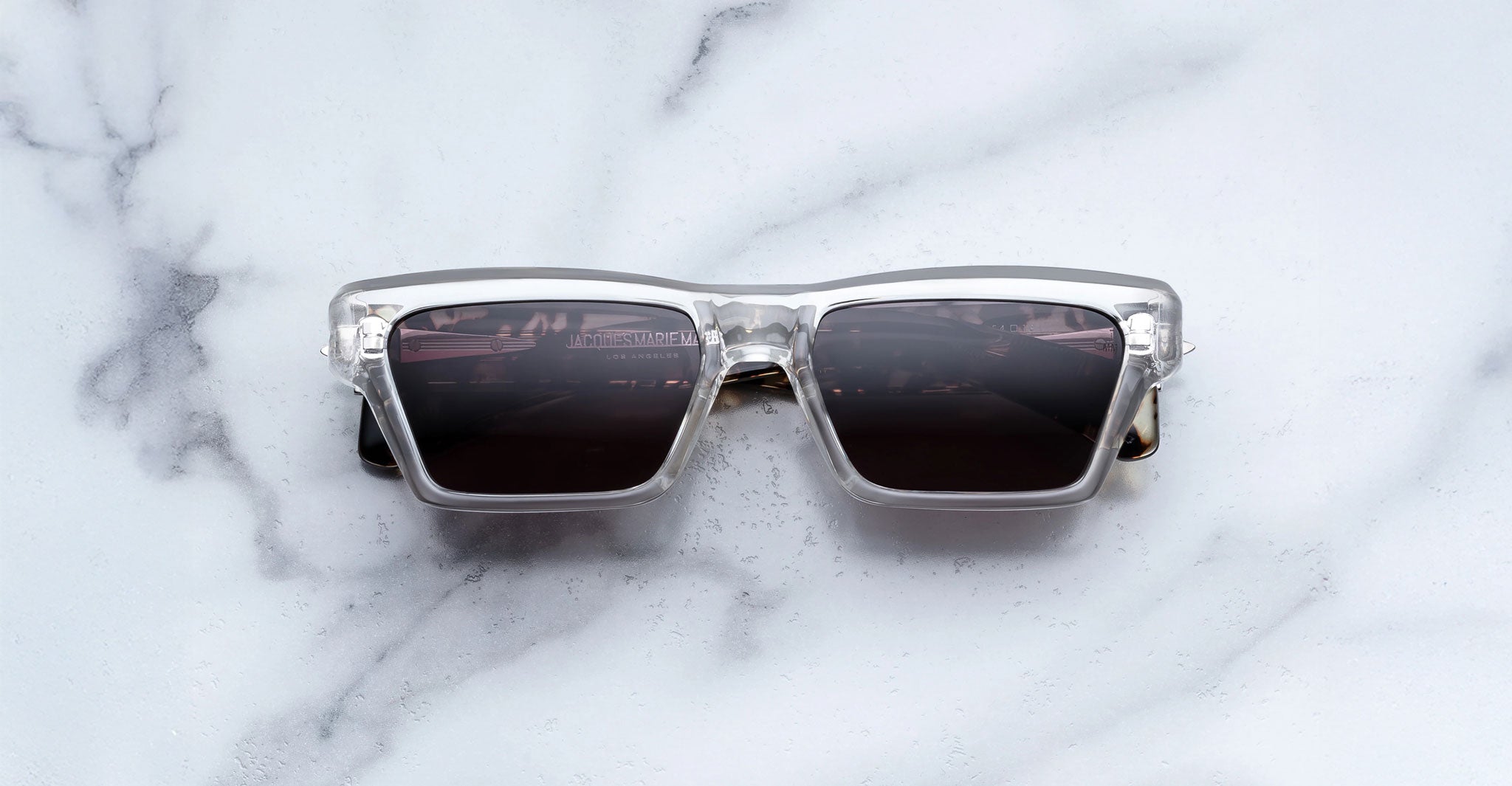 Jacques Marie Mage Melchior clear frame polarized sunglasses with dark lenses shown from above.