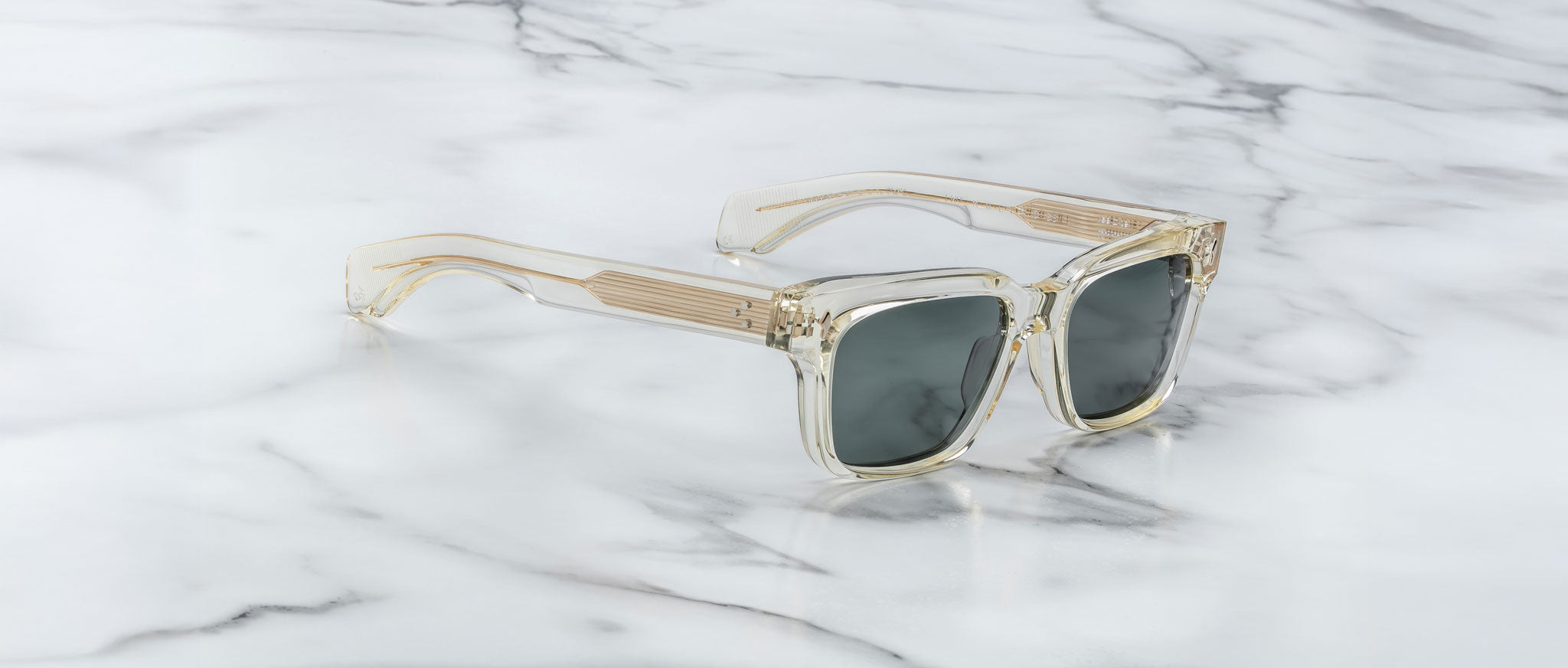 Jacques Marie Mage Molino 55 sunglasses feature clear frames and dark lenses, shown from above.