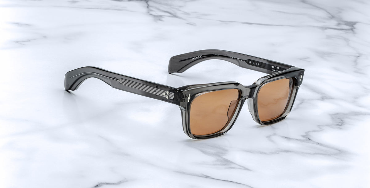 Jacques Marie Mage Molino 55 sunglasses, shown from the front, feature translucent gray square frames and UV-protection brown lenses.