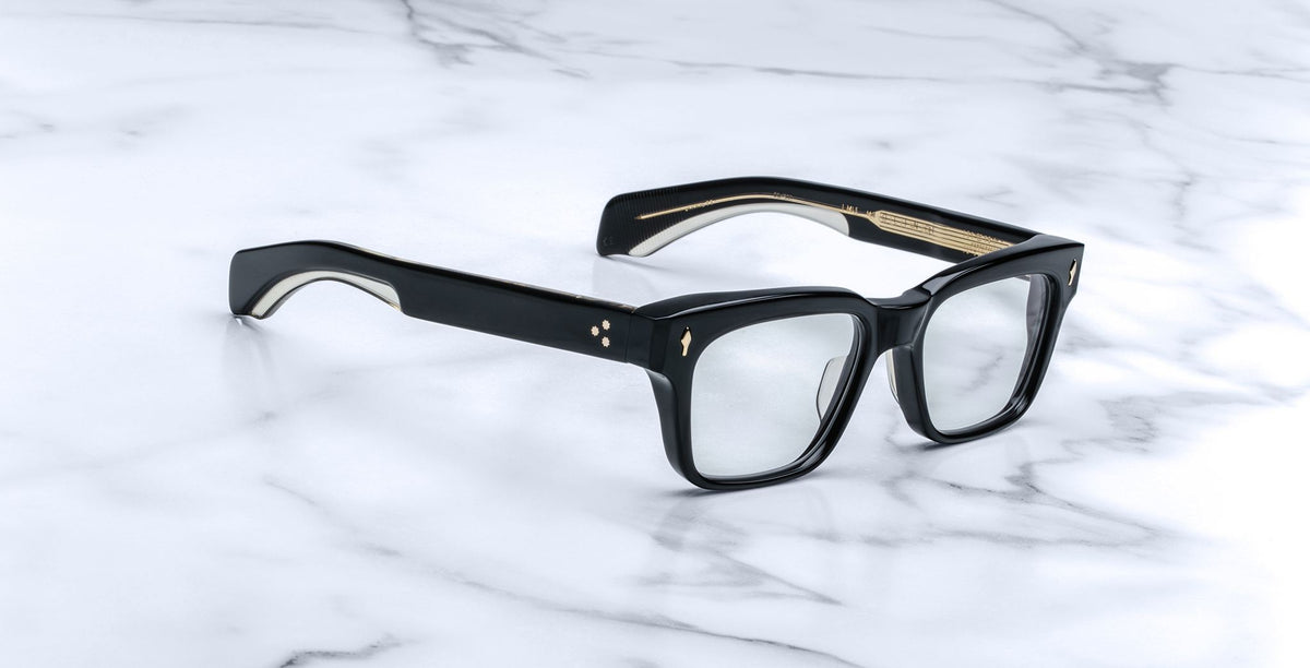 Jacques Marie Mage Molino black eyeglasses with clear lenses and gold accents, shown from above.