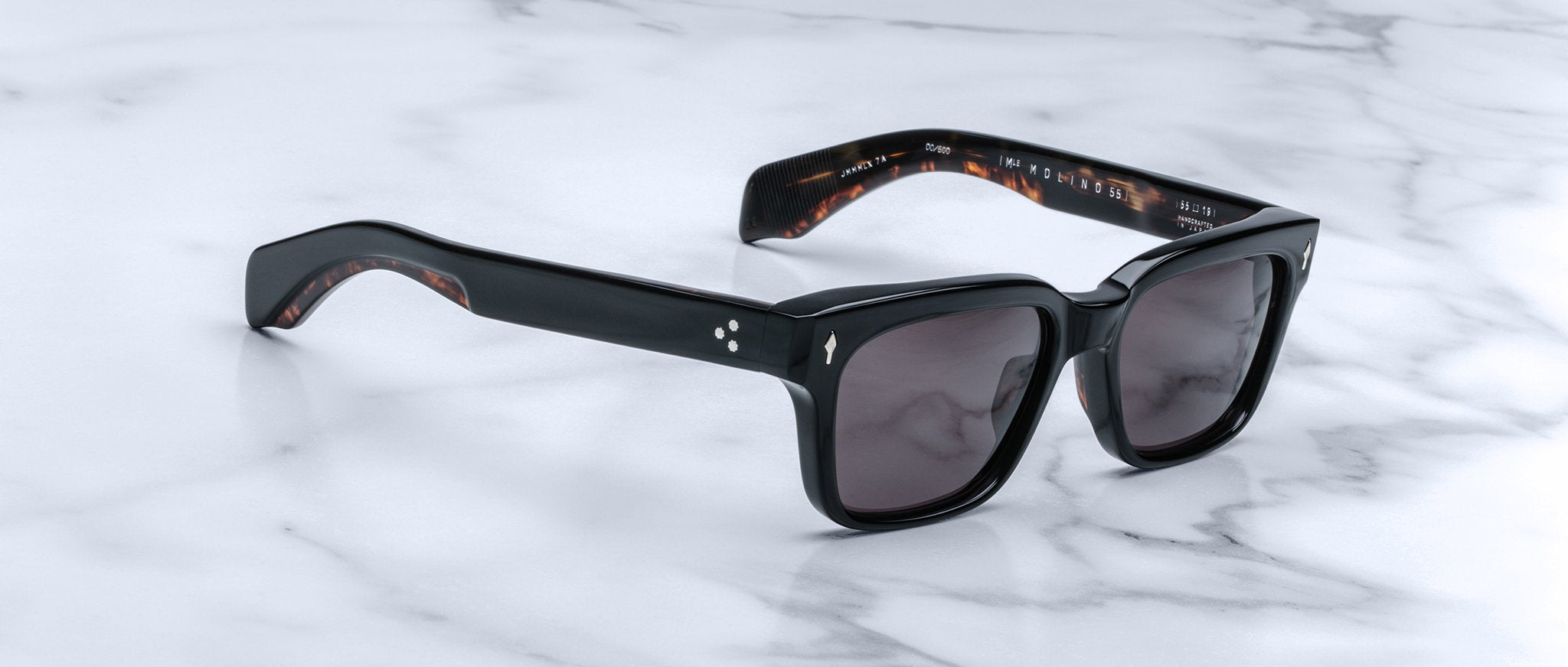 Jacques Marie Mage Molino 55 sunglasses with black square frames and dark lenses, viewed from above.