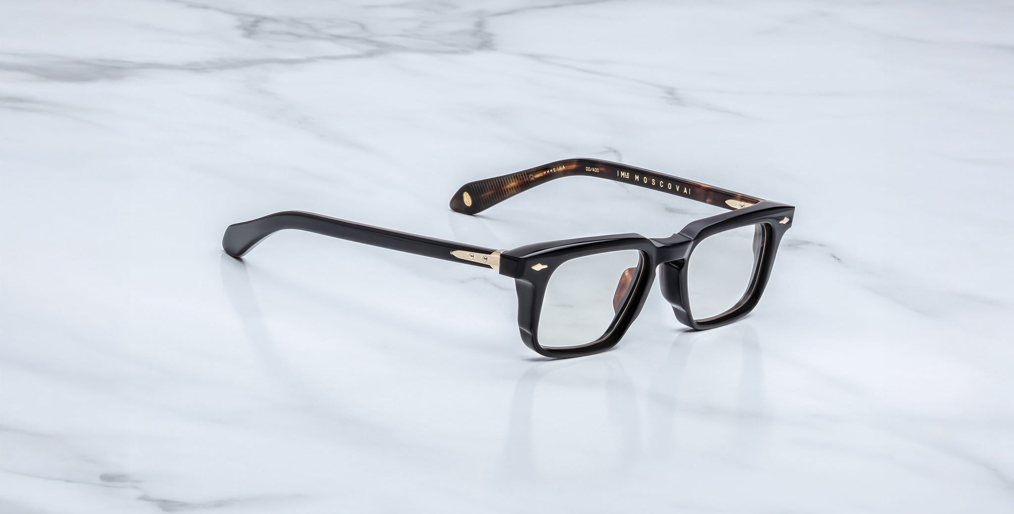 Jacques Marie Mage Moscova in Noir 15 acetate optical frame with rectangular lenses, sculpted black front, gold arrowhead pins, and exposed metal core temples with tortoiseshell interior detailing