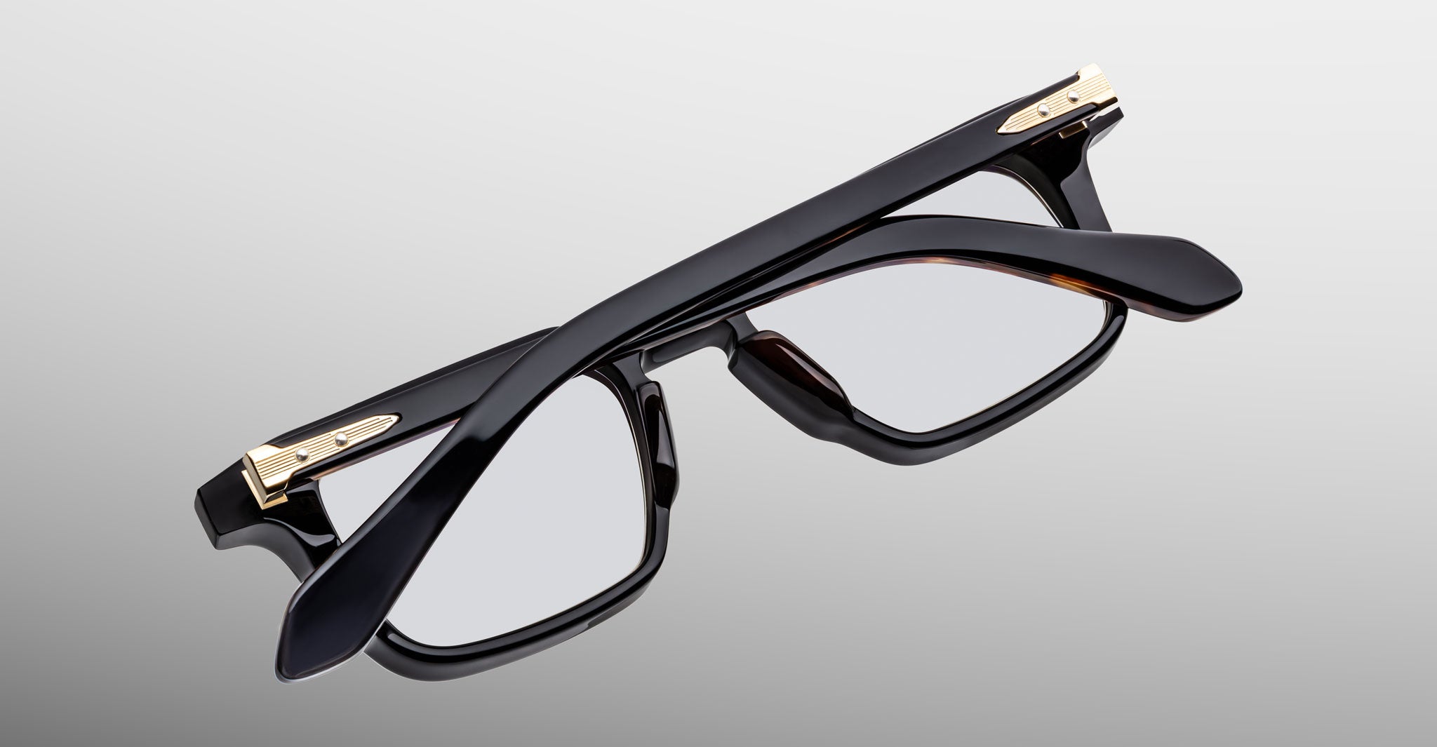 Jacques Marie Mage Moscova in Noir 15 acetate optical frame, top-down angled view showcasing bold rectangular silhouette, polished black acetate, arrowhead front pins, and gold monoblock hinges with sculpted temples