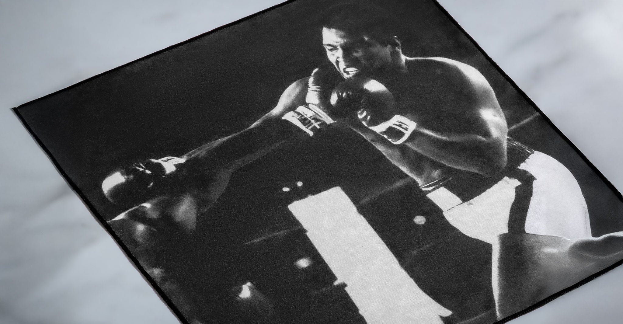Black-and-white image of a boxer mid-punch in the ring, wearing Jacques Marie Mage Louisville eyeglasses, front view.