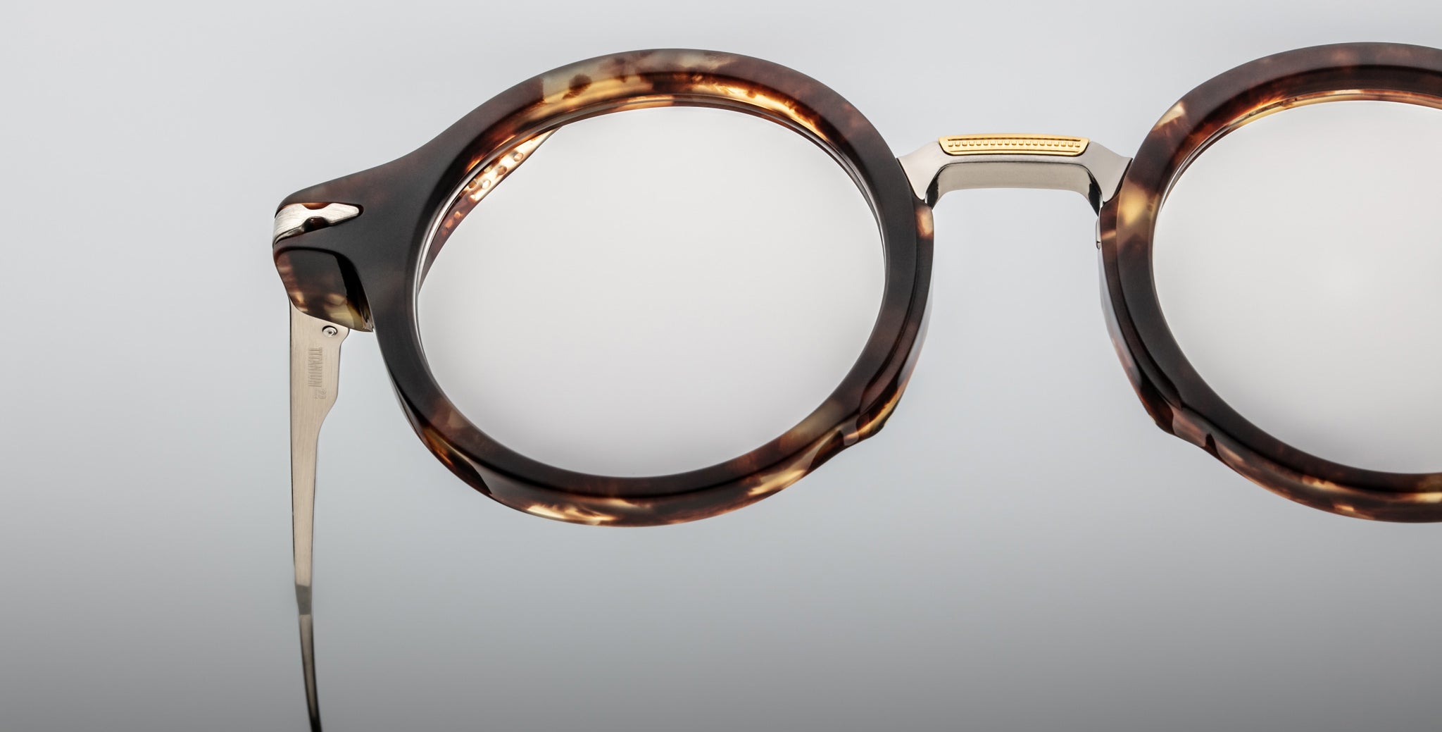 Close-up of Jacques Marie Mage Norman eyeglasses, round tortoiseshell frames with metal temples, front angle.