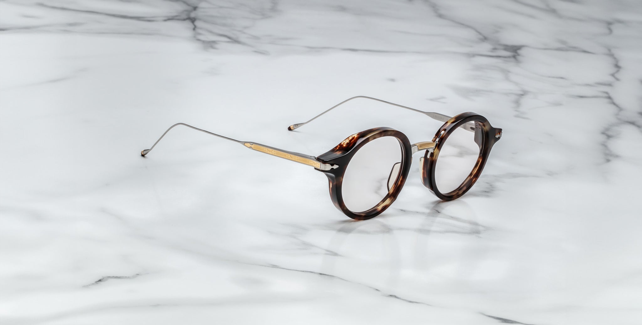 Jacques Marie Mage Norman round tortoiseshell eyeglasses with thin gold arms, shown from above.