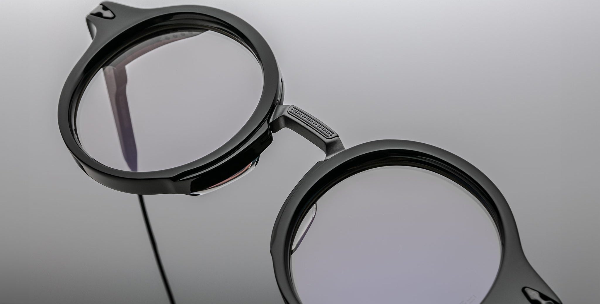 Close-up of Jacques Marie Mage Norman black round eyeglasses with clear lenses, front angle. Eyewear product shot.