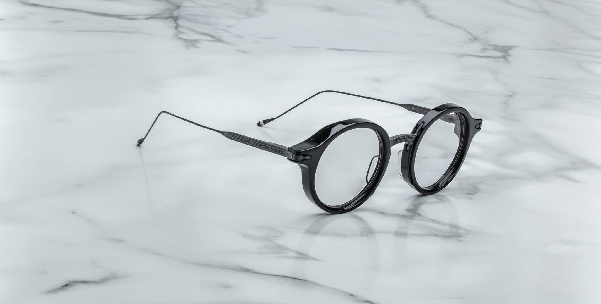 Jacques Marie Mage Norman eyeglasses, open and viewed from above, displayed on a flat white surface.