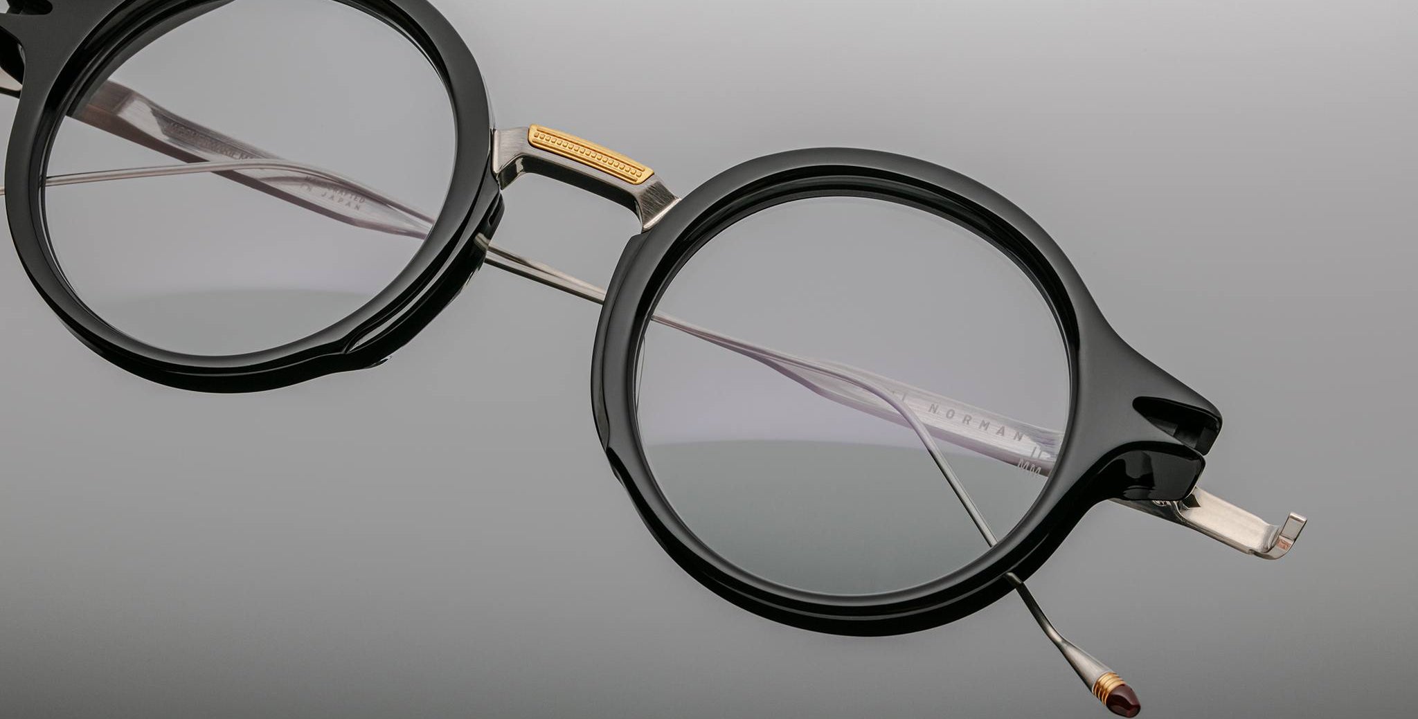 Jacques Marie Mage Norman round black eyeglasses with metal bridge and temples, close-up angle.