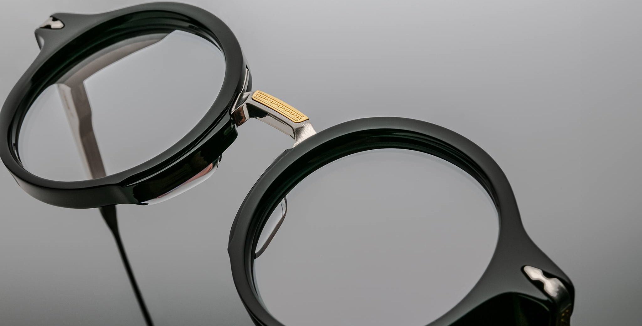 Close-up of Jacques Marie Mage Norman round black eyeglasses with gold bridge; product shown from the front.